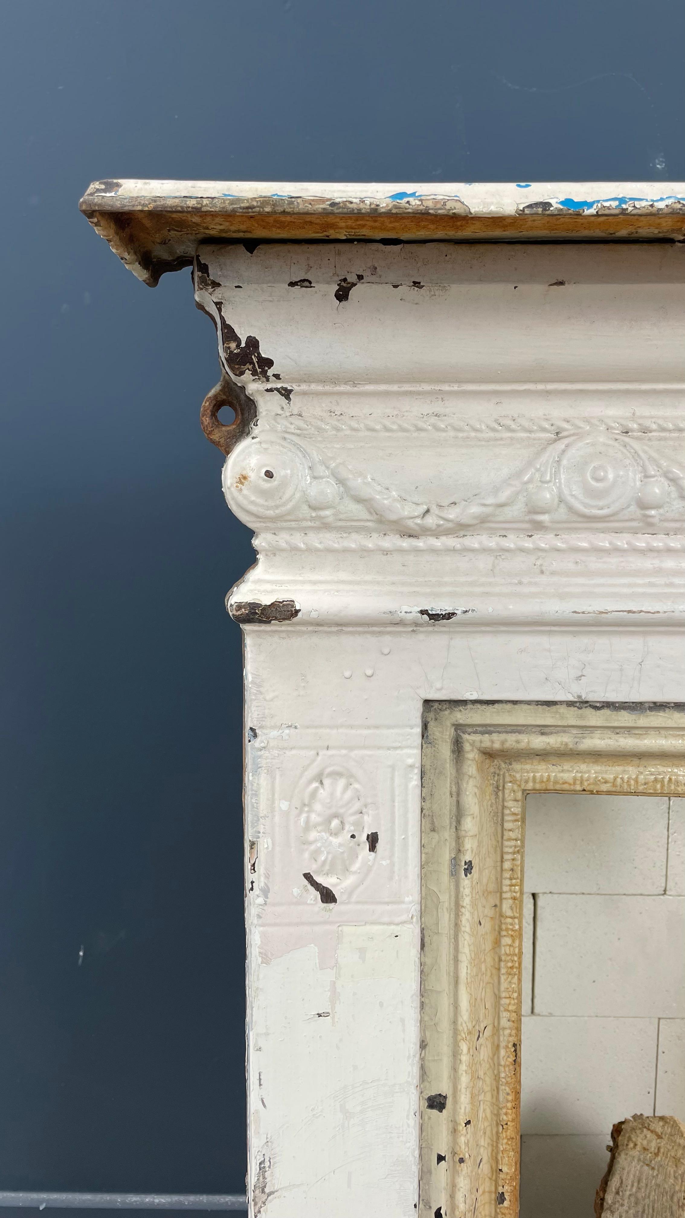 A beautiful antique English cast iron fireplace with original patina. This beautiful cast iron fireplace has not been restored and therefore has a beautiful original patina. This cast iron fireplace is supplied including white refractory bricks (see