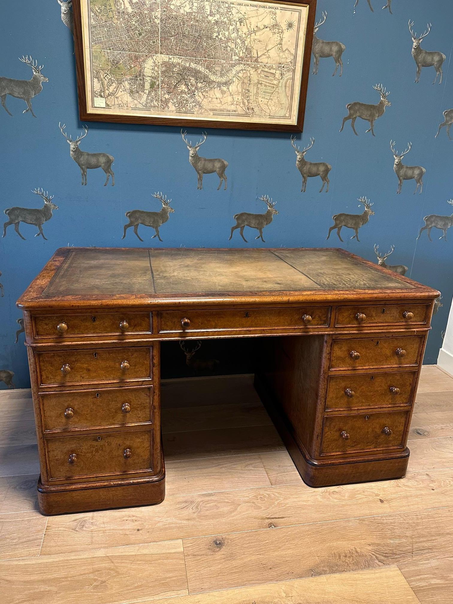 A beautiful, pure antique burl walnut desk with a leather top. It is in perfect, original condition. It has a wonderfully weathered look and a warm color. It is finished all around, allowing it to stand freely in a room. The quality of the desk is