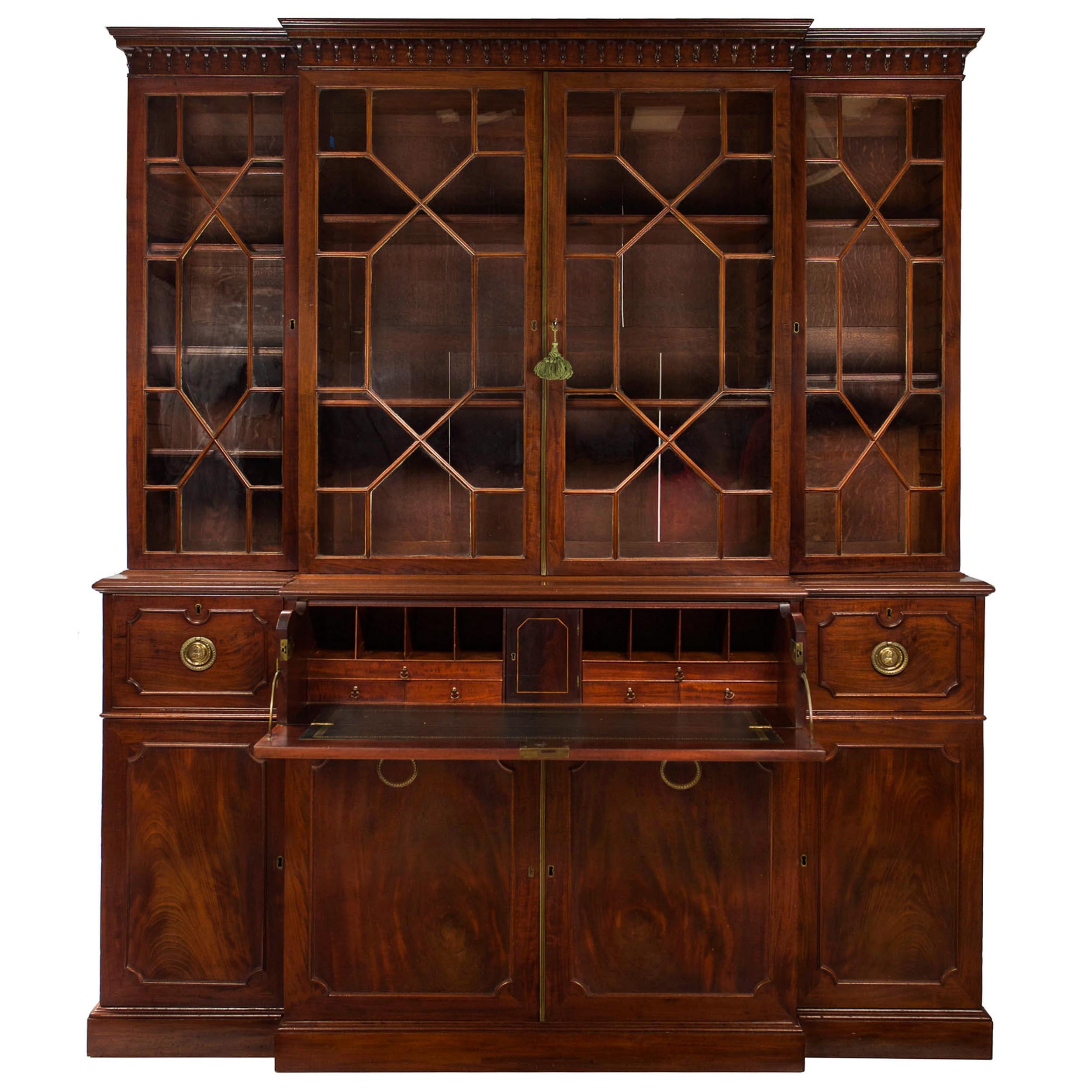 A very fine breakfront bookcase cabinet executed in the George III taste with exacting standards of craftsmanship, it shows impeccable taste in material choice with a rich and dense mahogany utilized and showcased throughout. The drawers exhibit