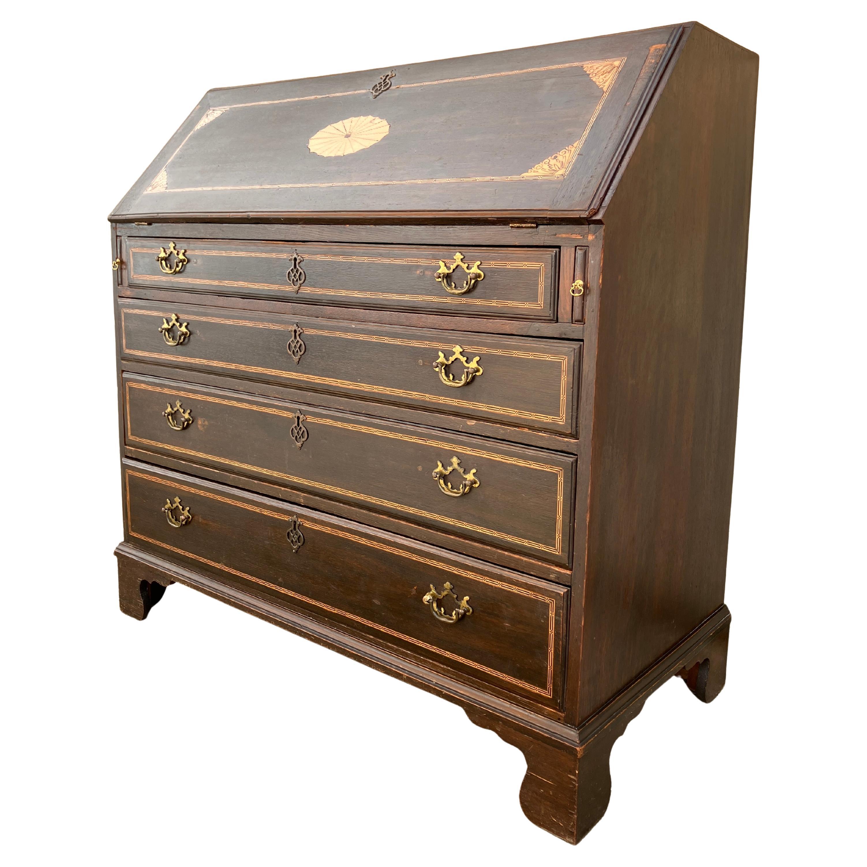 A stunning English Georgian bureau. This bureaux is from the Georgian era, just after 1800. Fabulous color and patina to the solid oak finish. The whole piece of furniture is made of solid oak, even the drawers. Beautiful inlay details on the sloped