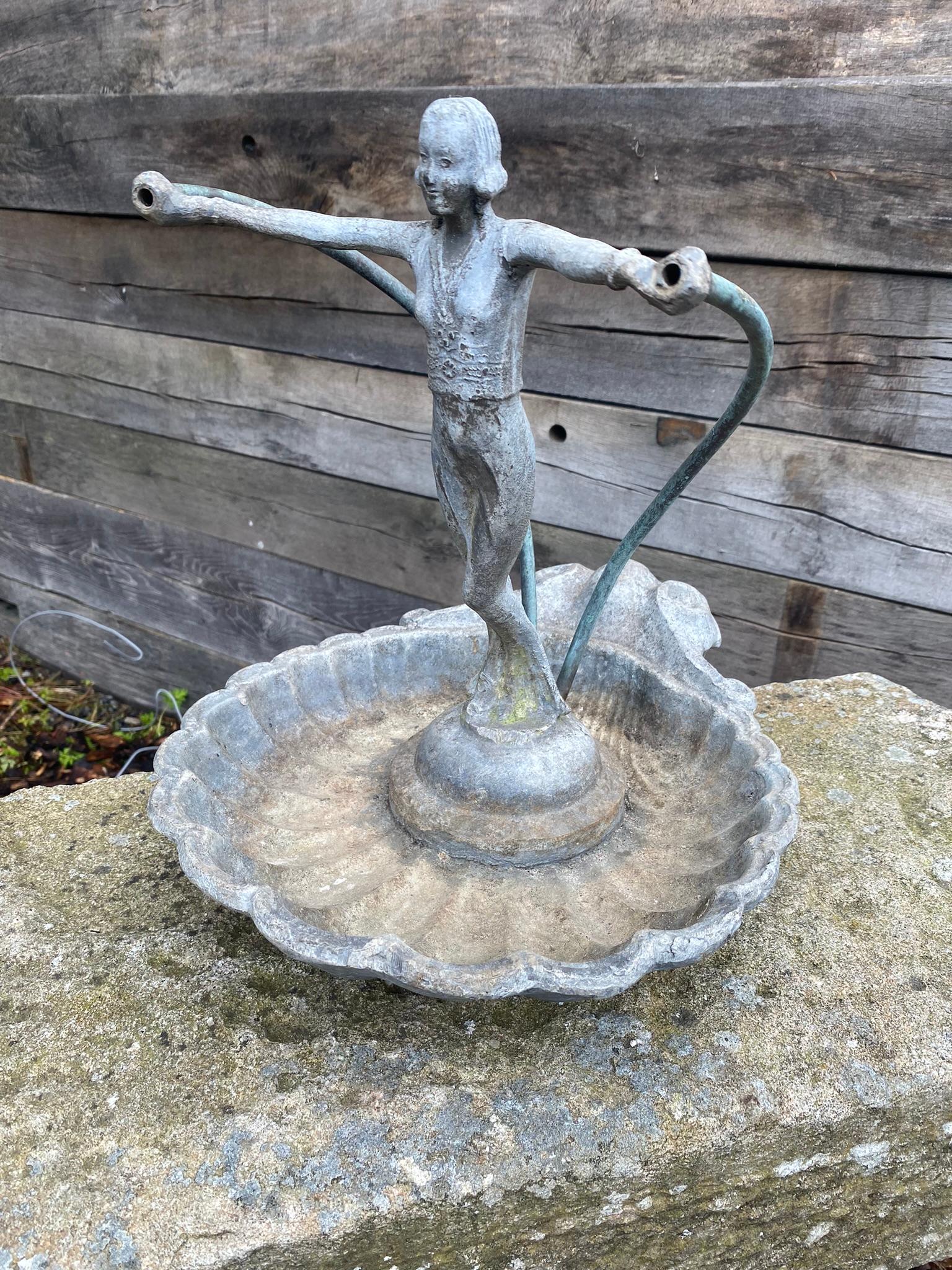 An elegant and highly unusual figural fountainhead. Made from cast lead, this is a late 19th century / early 20th century piece of superb quality. The lady figure is standing upright and has a graceful appearance leaning forward and holding two