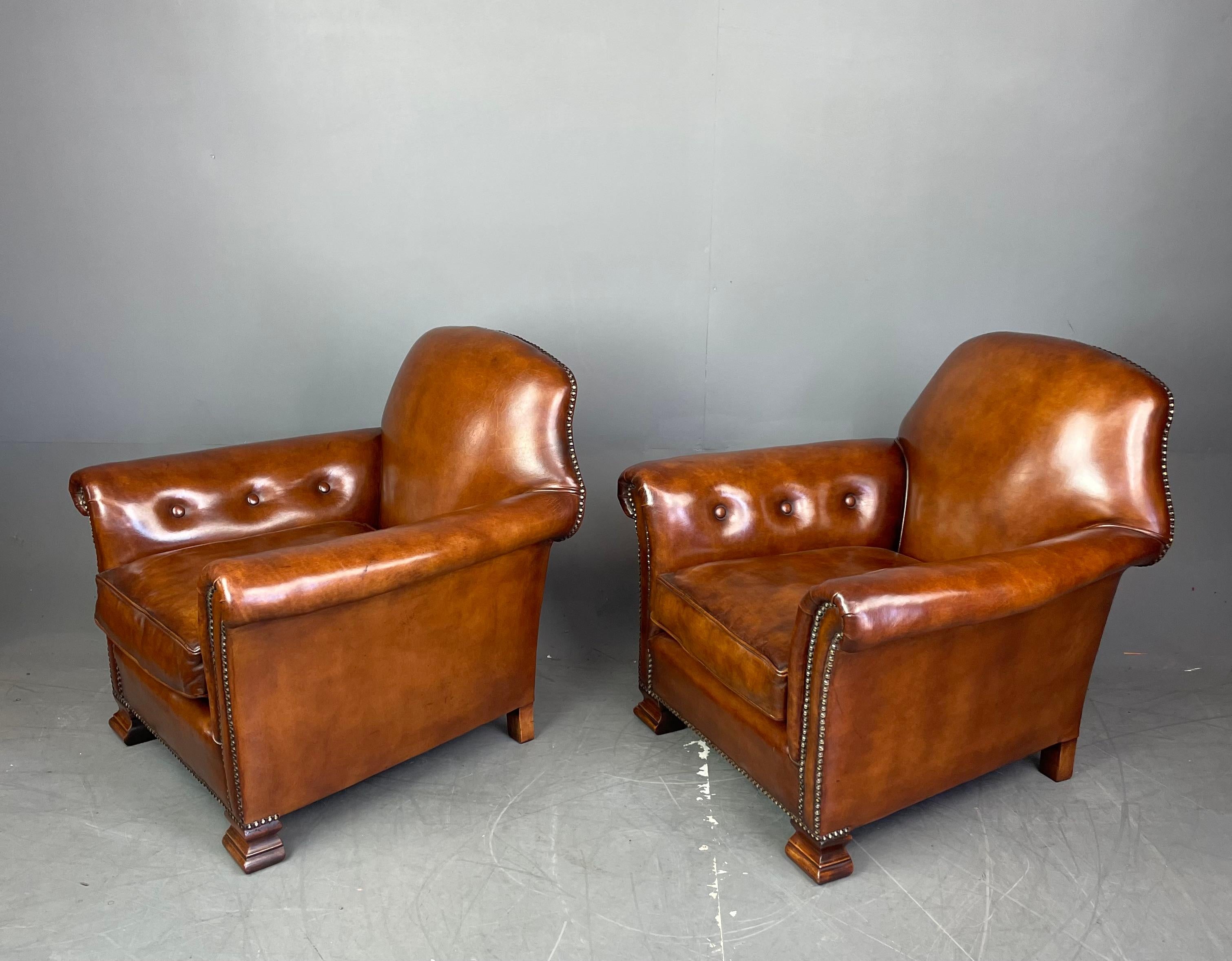 Fine pair of Edwardian leather arm chairs .
They have been fully refurbished to the highest of standards and are upholstered in the finest English leather .
They are hand dyed and finished giving a wonderful unique antique finish and a great deep