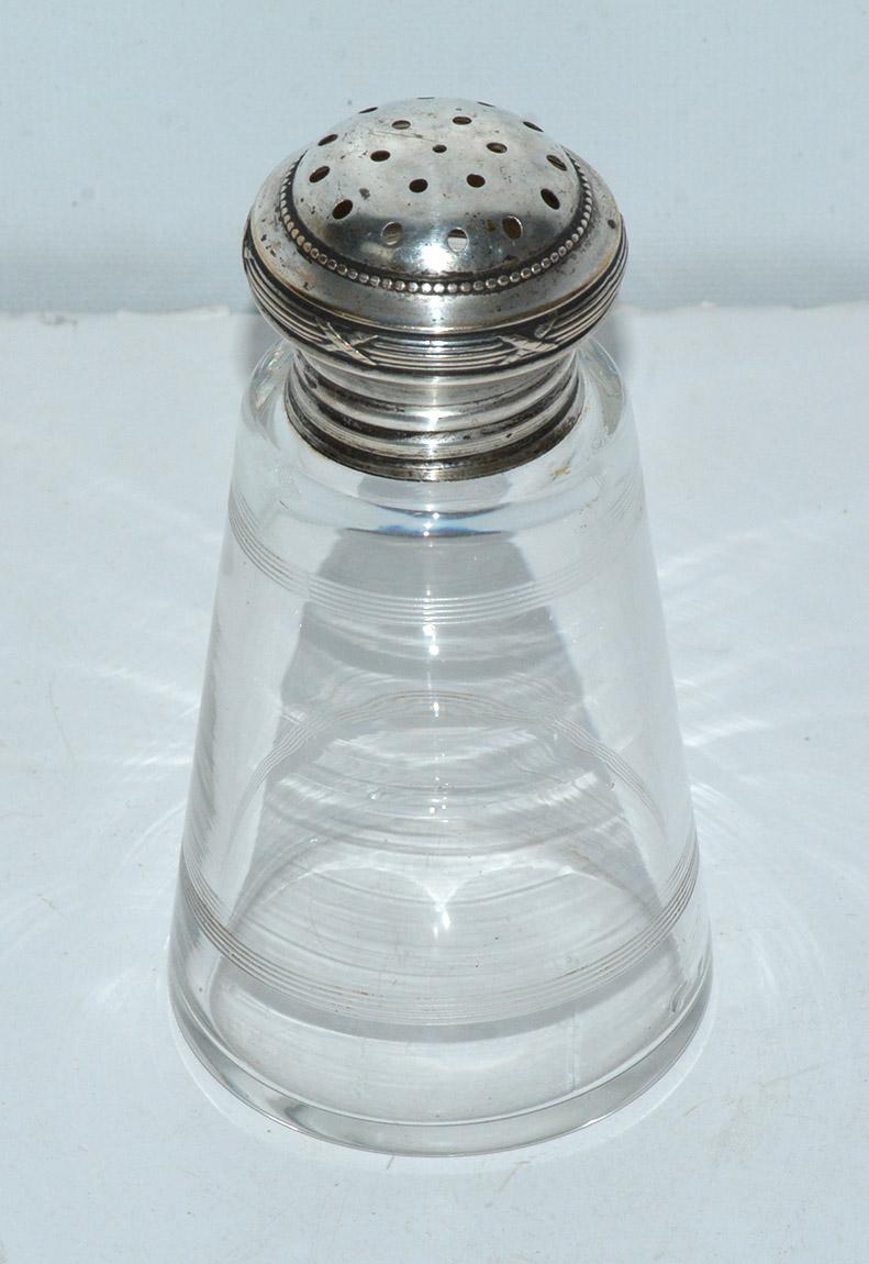 The English antique sugar Shaker was used at tea time although it could be used for other shakeable spices -- cocoa, cinnamon to name a couple. The glass bottom has engraved decorative rings top and bottom. The cap is made of silver plate with a
