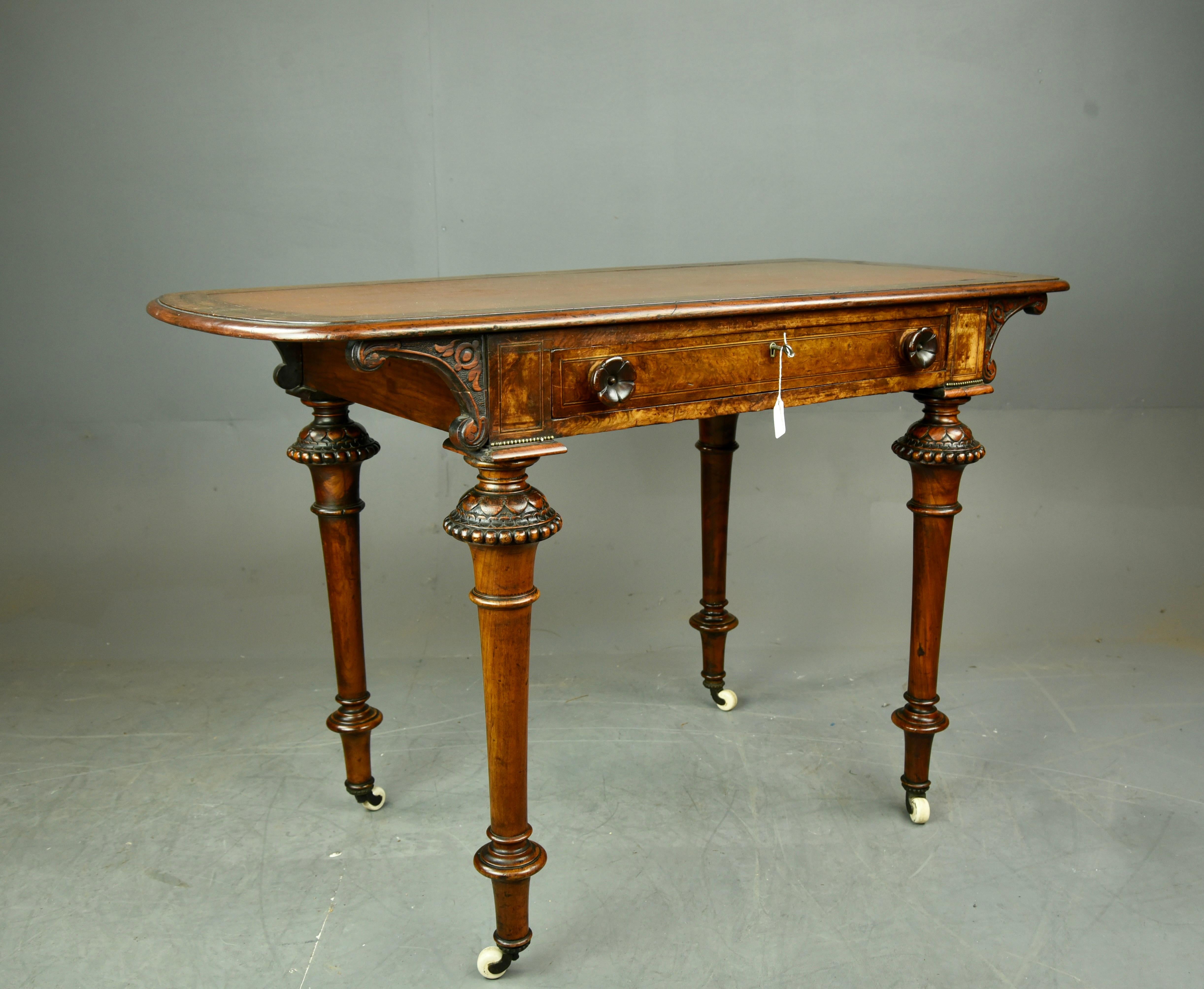 Fine Quality Victorian burr walnut ladies writing table .
This unusual writing table Stands on fine tuned legs with ornate carved crowns to the top .
standing on original brass and porcelain castors ,the single full width drawer retain the original