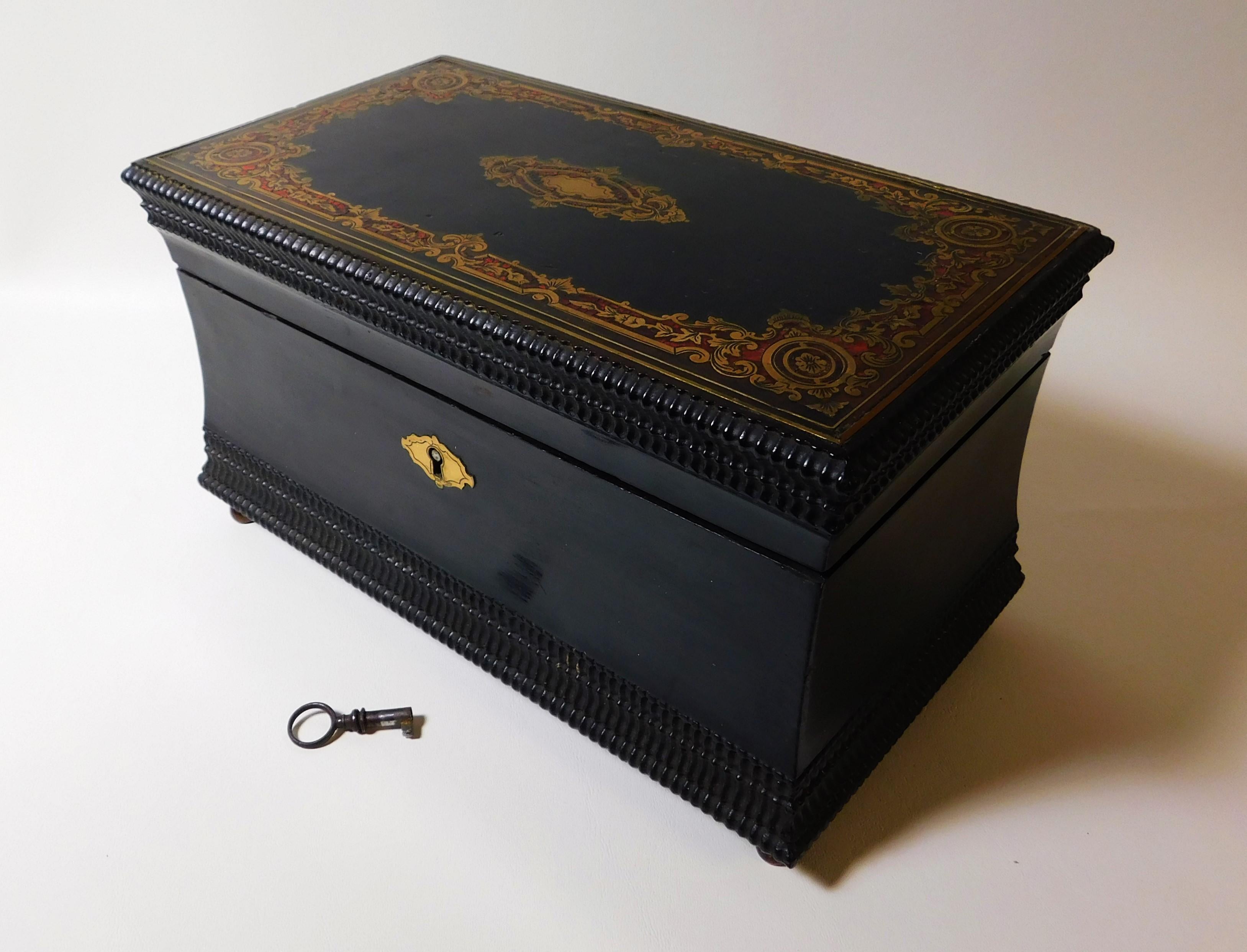 British ebony wood cigar box that was originally a tea caddy box that was converted in the early 20th century into a cigar box, circa 1840s. Beautifully ebonized box on four feet with working brass lock and key and fine inlayed brass and red paint.