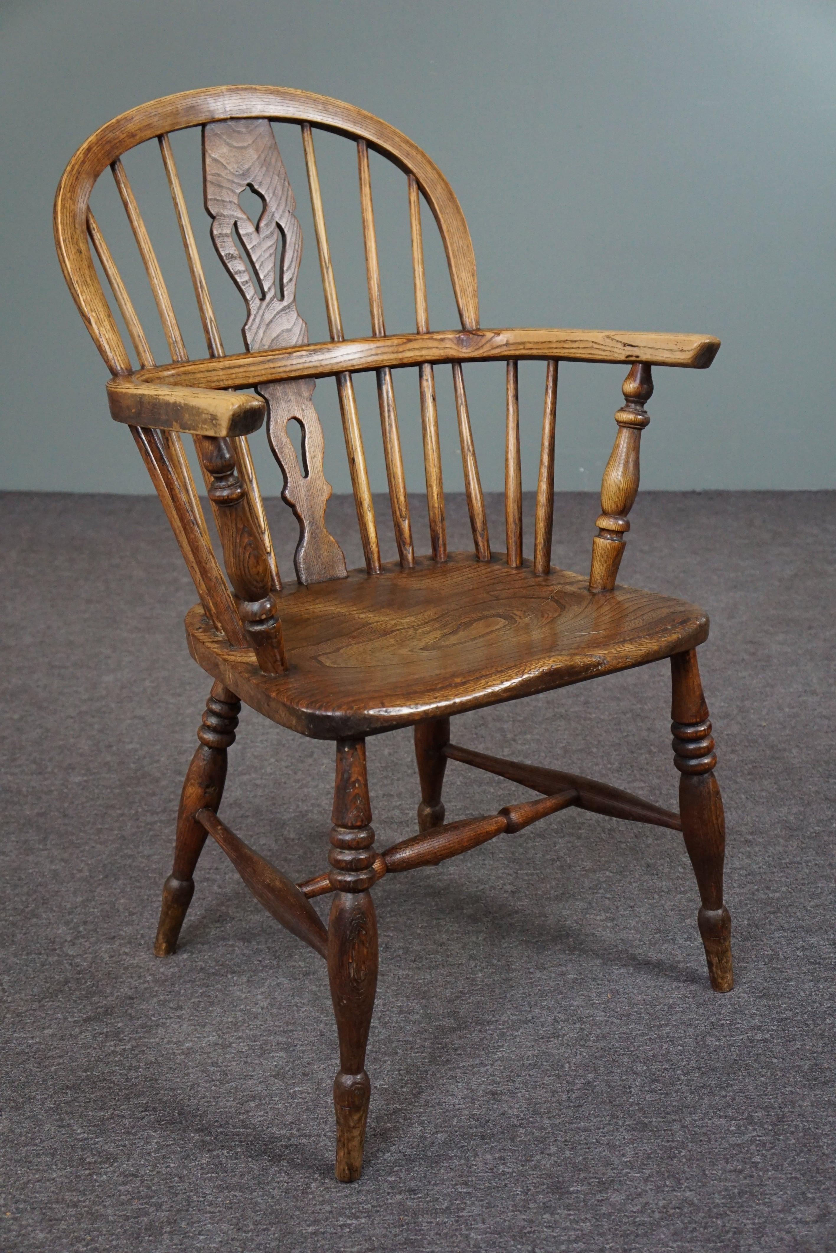 Offered is this beautiful antique armchair made of solid wood with a very beautiful characteristic appearance.

This striking English antique Windsor armchair with armrests has a well-shaped thick solid wooden seat. The chair has charming turned