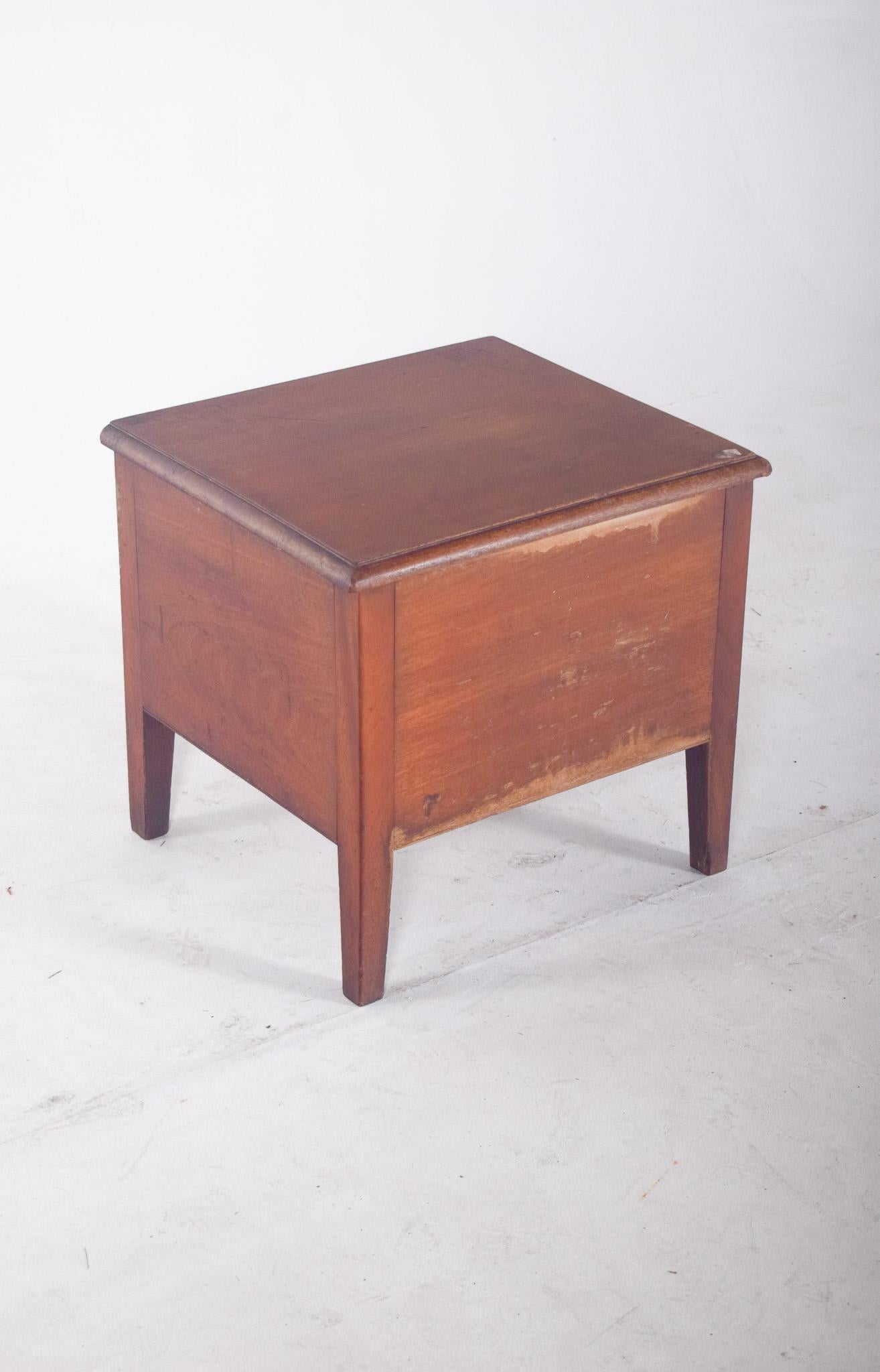 Armoire antique en bois. Avec un design minimaliste et une structure rectangulaire compacte, le meuble est doté d'un couvercle supérieur articulé, fixé par des charnières métalliques, qui, une fois ouvert, révèle l'assise avec un trou circulaire et