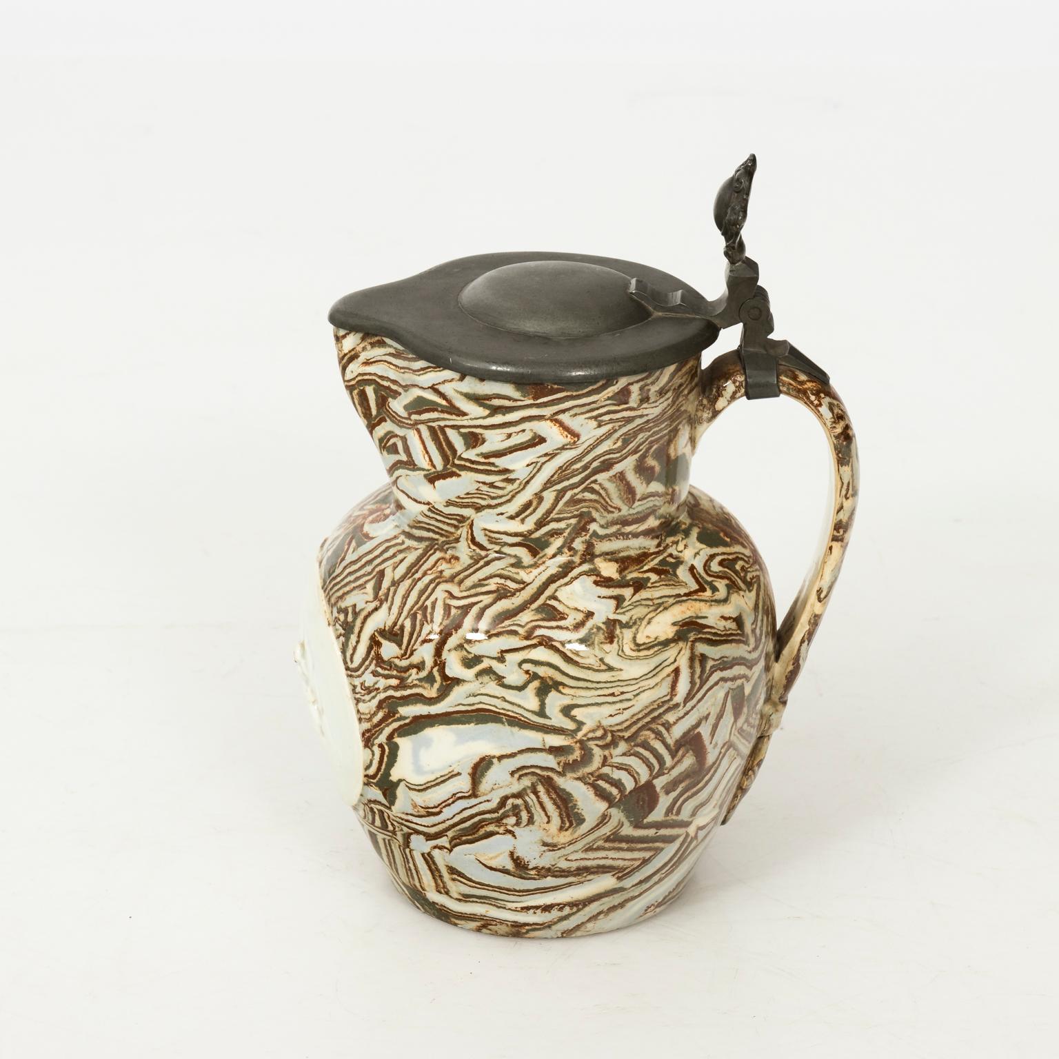 English brown aptware jug with pewter lid in a glazed finish, circa 1880.
  