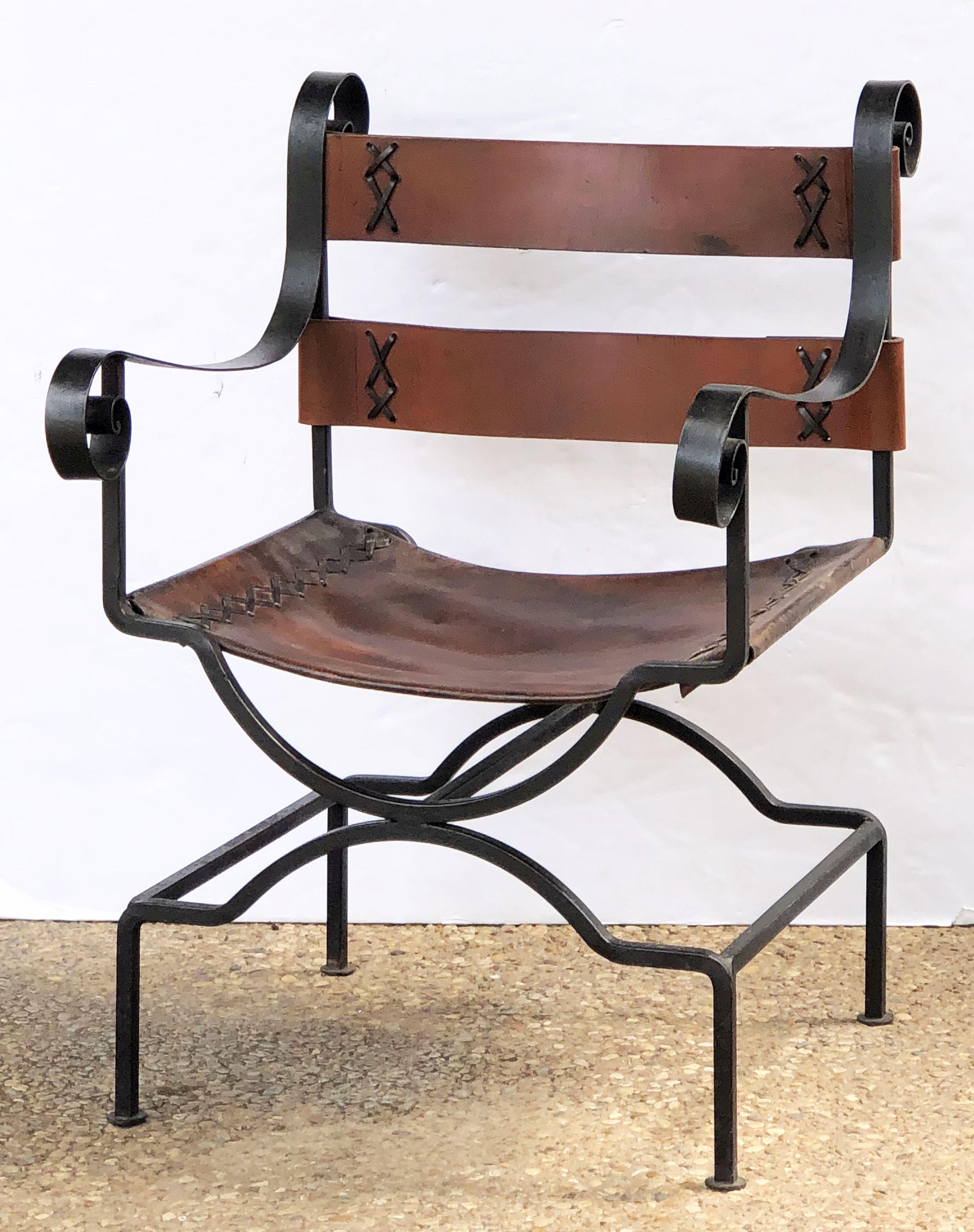 A fine English arm chair or lounge chair, featuring a comfortable back and seat of leather on a stylish, wrought iron frame.