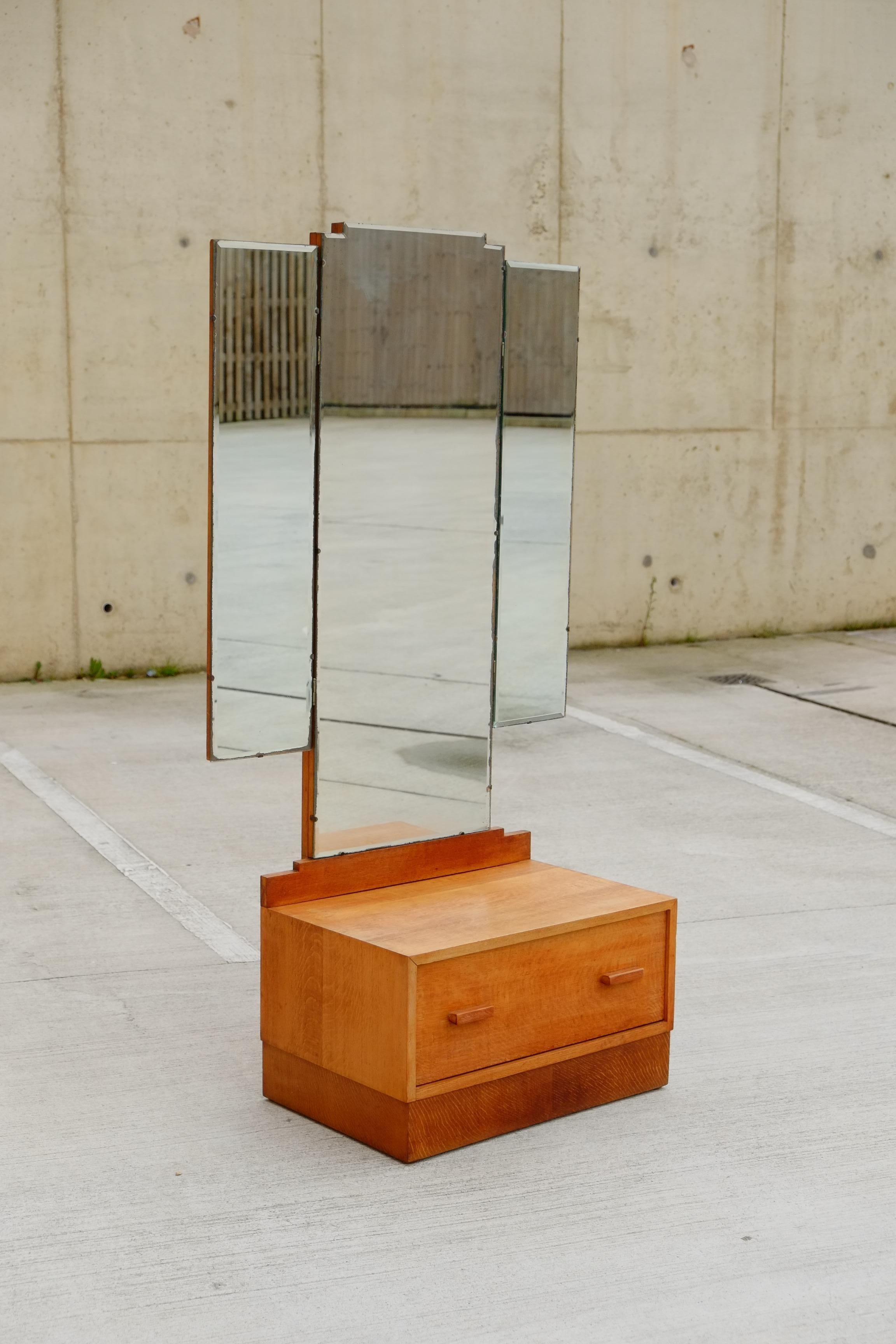 A beautifully simple 1930s Art Deco triple dressing mirror / vanity from England. This vanity has a single deep drawer of solid oak with simple oak wood drawer handles. Above is a large geometric triple folding dressing mirror. 

Size approx;