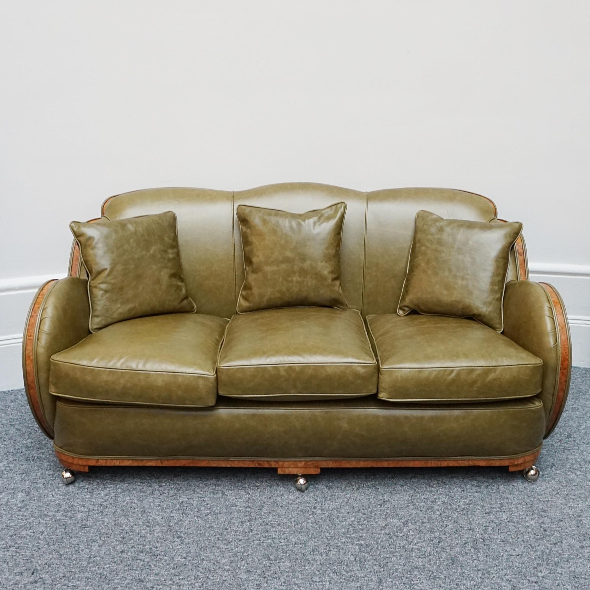 An Art Deco 'Cloud' Sofa by Harry & Lou Epstein. Three seater cloud back sofa with burr walnut show wood banding that runs throughout. Re-upholstered in olive green leather. 

Designer: Harry & Lou Epstein

Dimensions: H 77cm W 163cm D 80cm Seat H