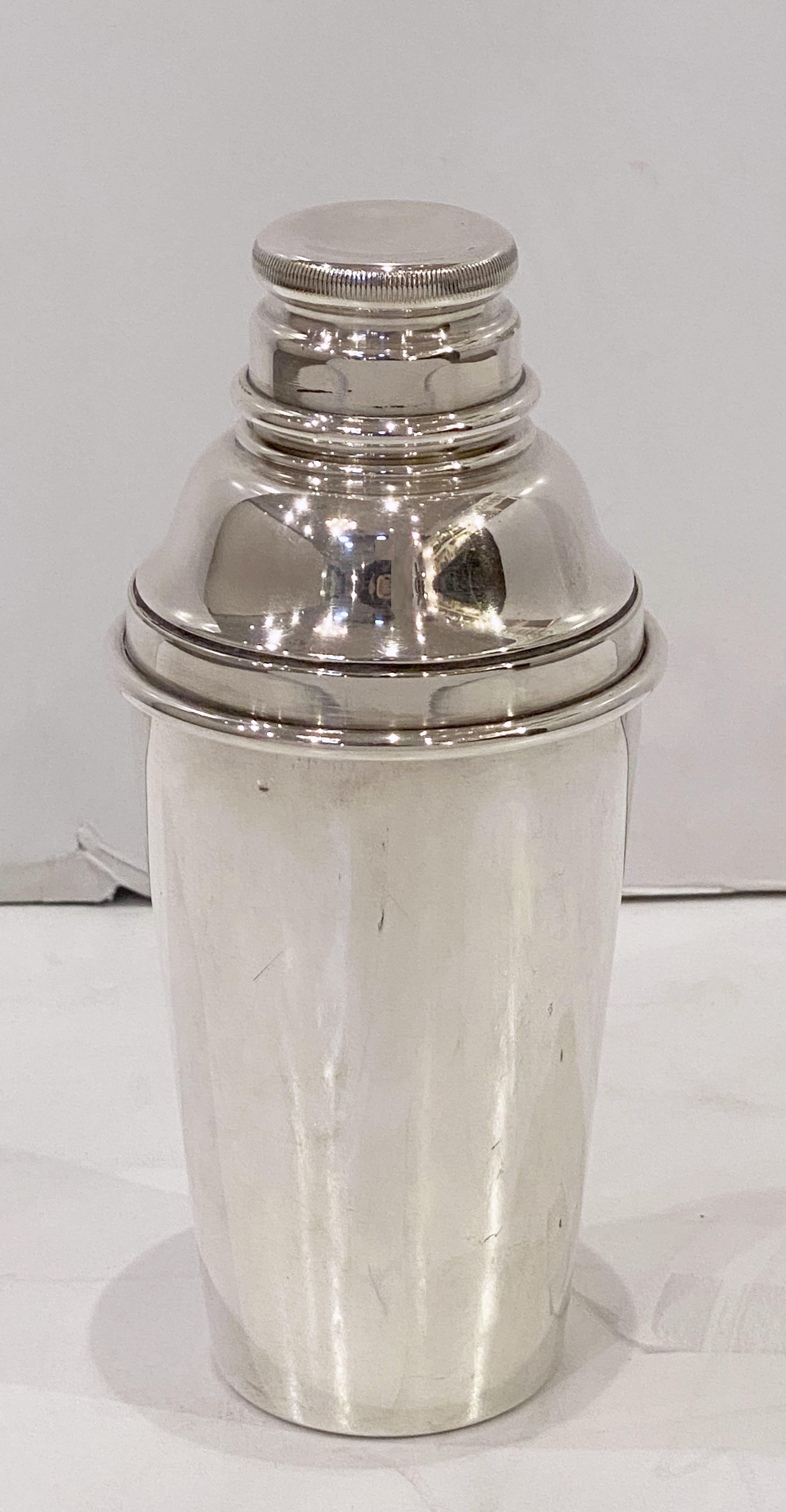 A vintage English cylindrical martini or cocktail shaker of fine plate silver from the Art Deco period, circa 1930-1940, with engine-turned removable cap and strainer.

Marked on base: Gaskell and Chambers, Birmingham.

Gaskell & Chambers’ roots