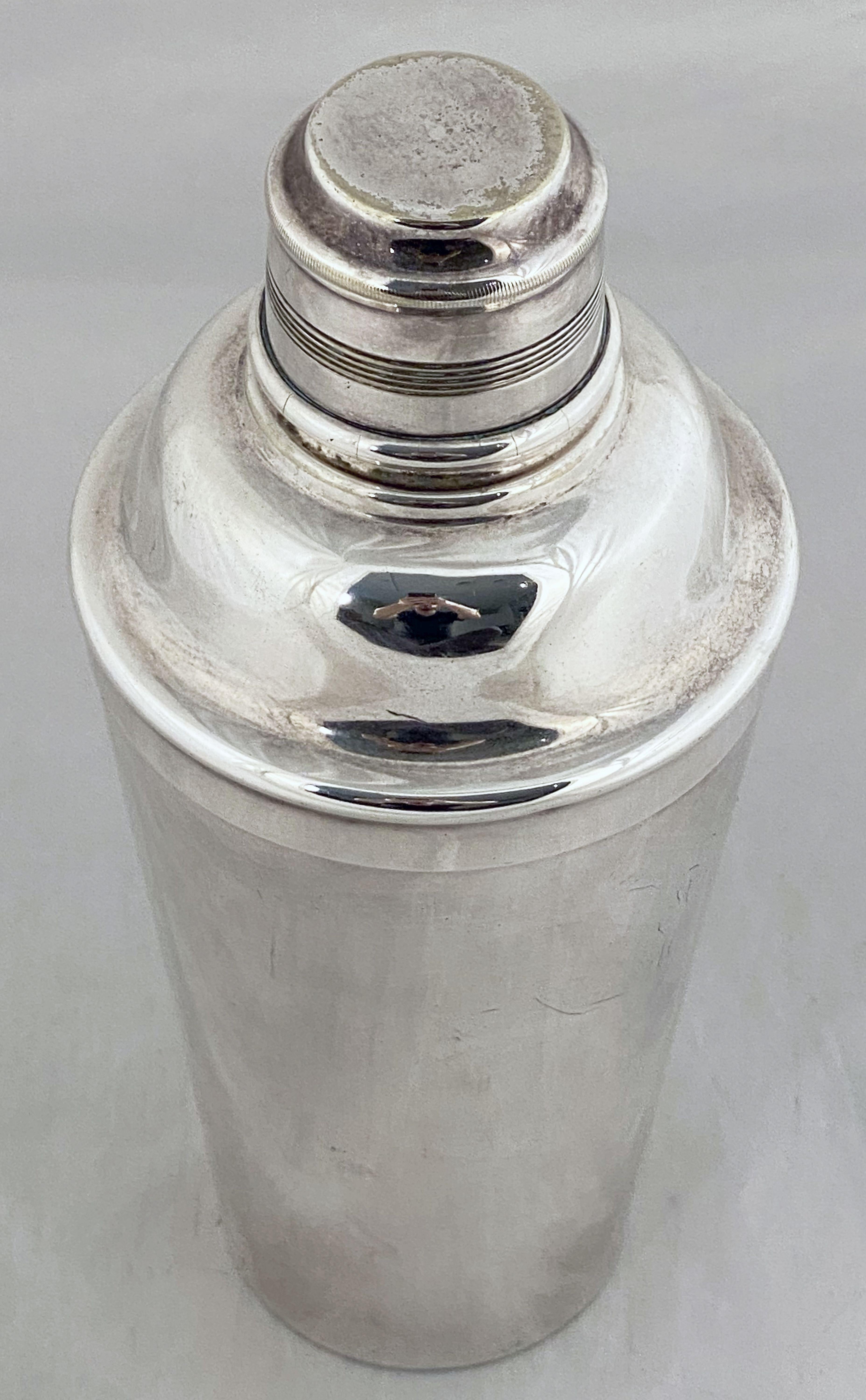 A vintage English cylindrical martini or cocktail shaker of fine plate silver from the Art Deco period, with engine-turned removable cap and strainer.

Marked on base: EPNS

Perfect for the bar. Even better for martinis.