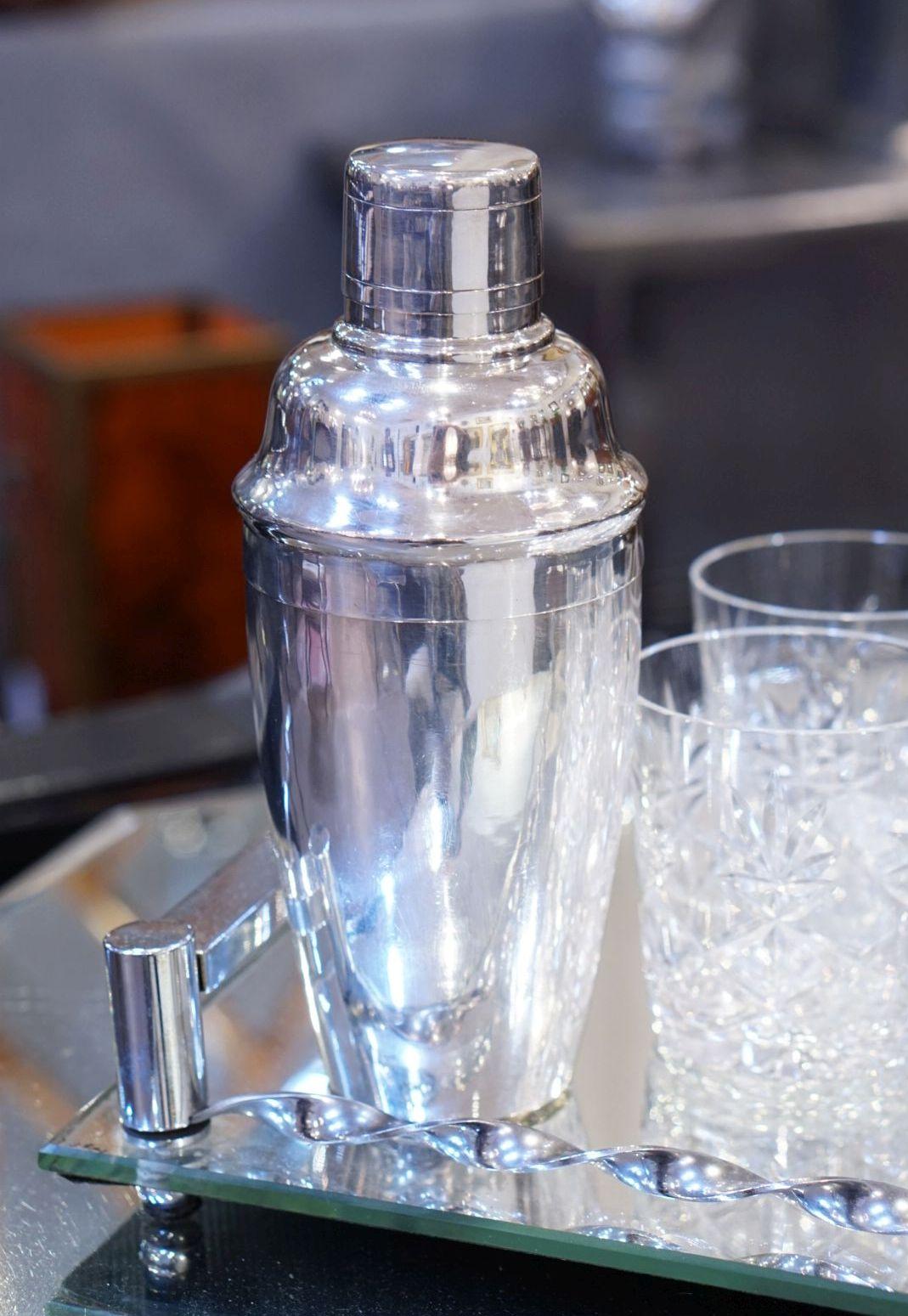 A vintage English cylindrical martini or cocktail shaker of fine plate silver featuring a stylish Art Deco design, with removable cap and strainer.

Impressed mark to base: Van Buren

Perfect for the bar. Even better for martinis.