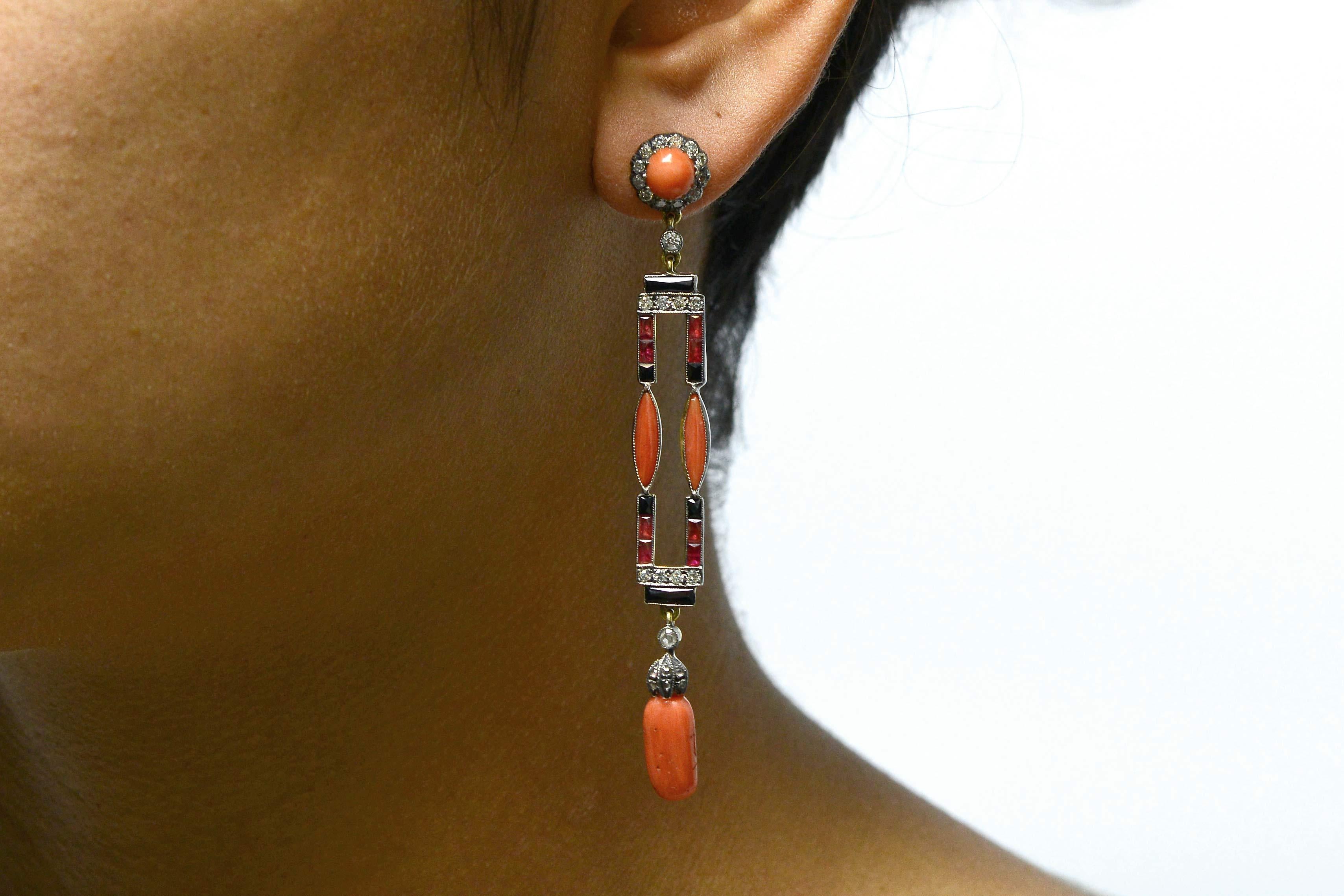 A dramatic pair of English Art Deco coral dangle earrings. The sweeping, shoulder duster drop earrings sway seductively and at 3