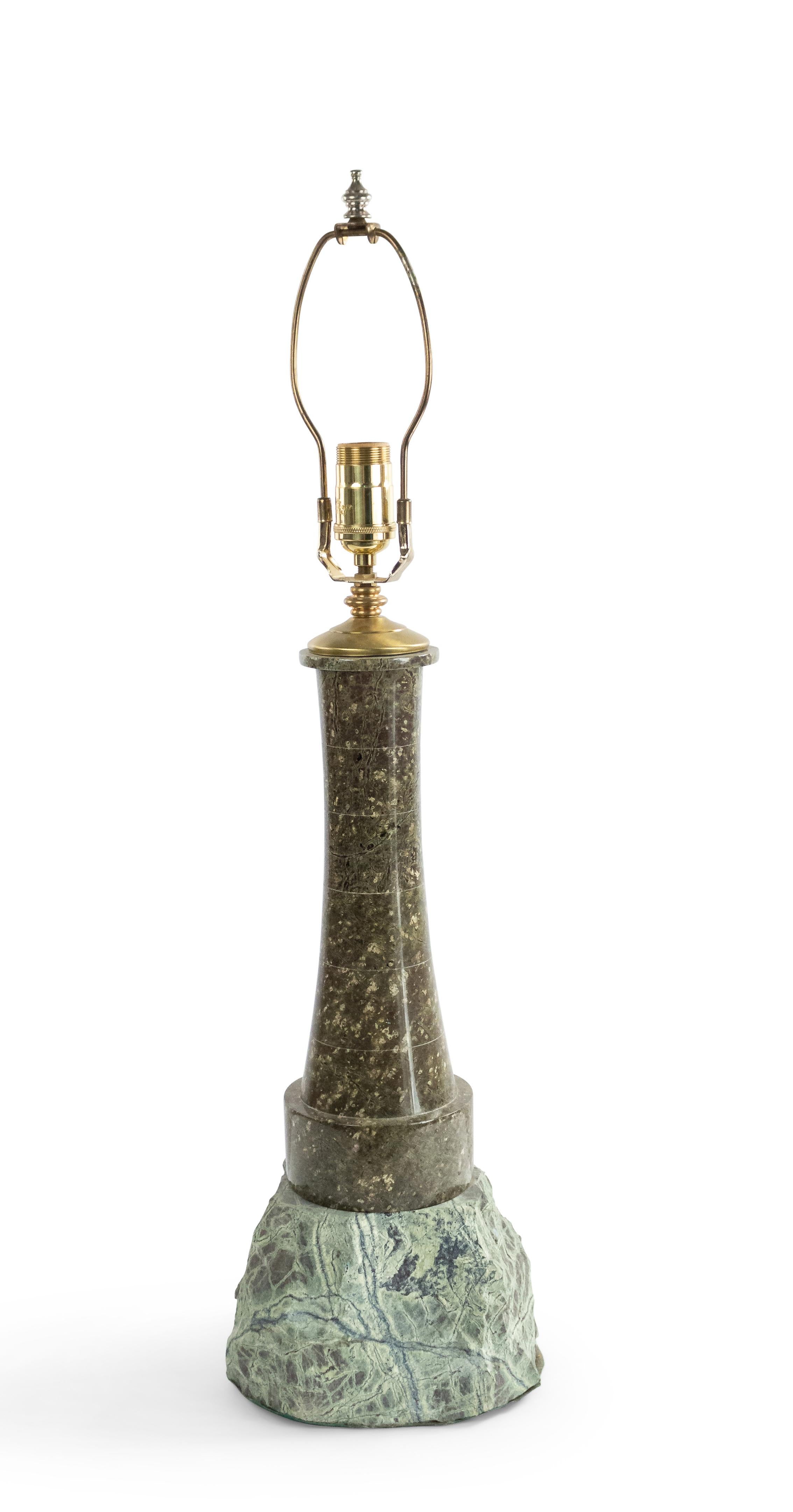 English Art Deco (Cornwall) stone table lamp in the form of a lighthouse perched on a rocky outcropping.
