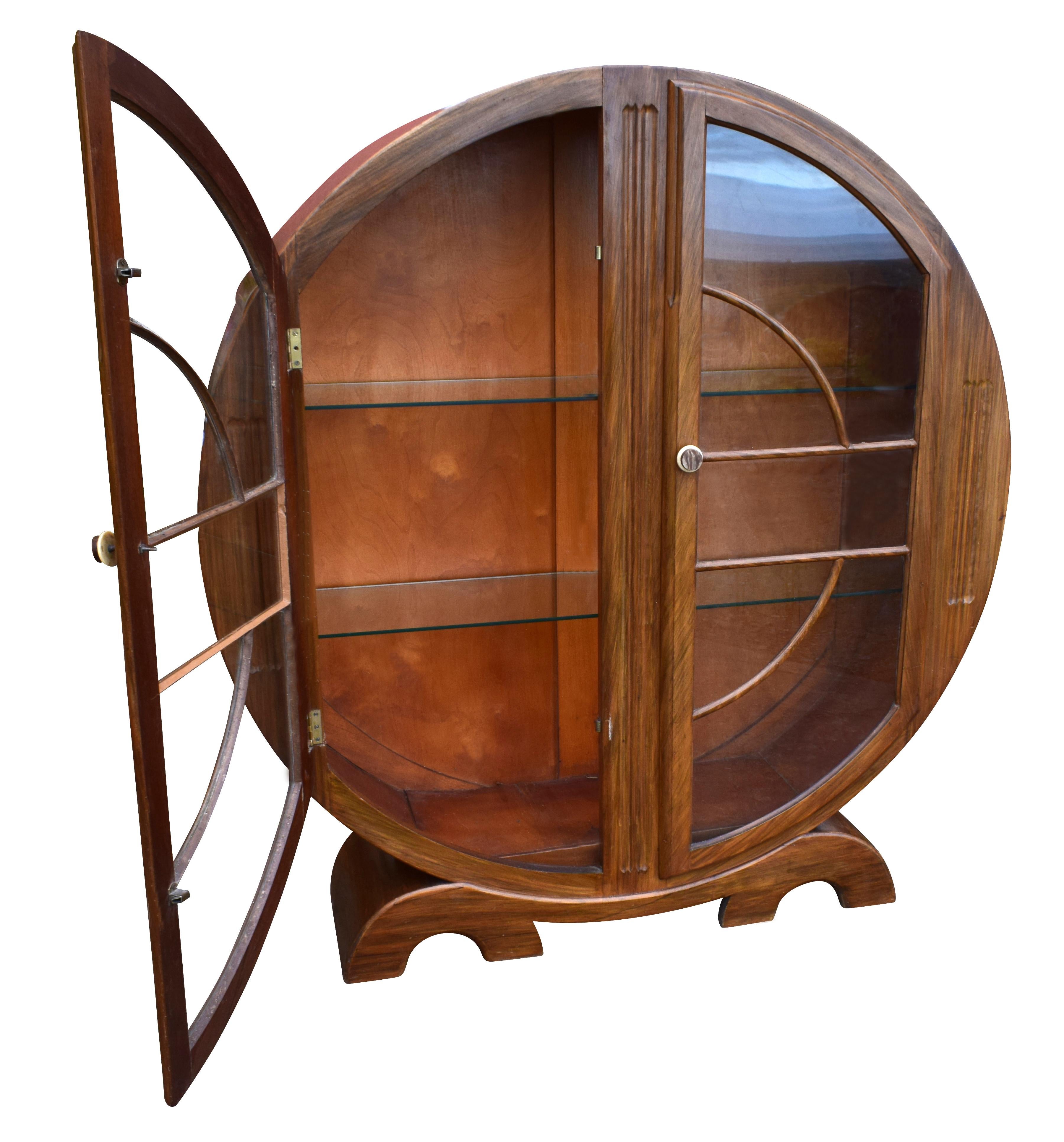 Every Art Deco interior should have one of these lovely 1930s English circular display cabinets. The high quality in beautiful walnut with ample internal storage makes this is a very functional piece. The two internal glass shelves are thick glass
