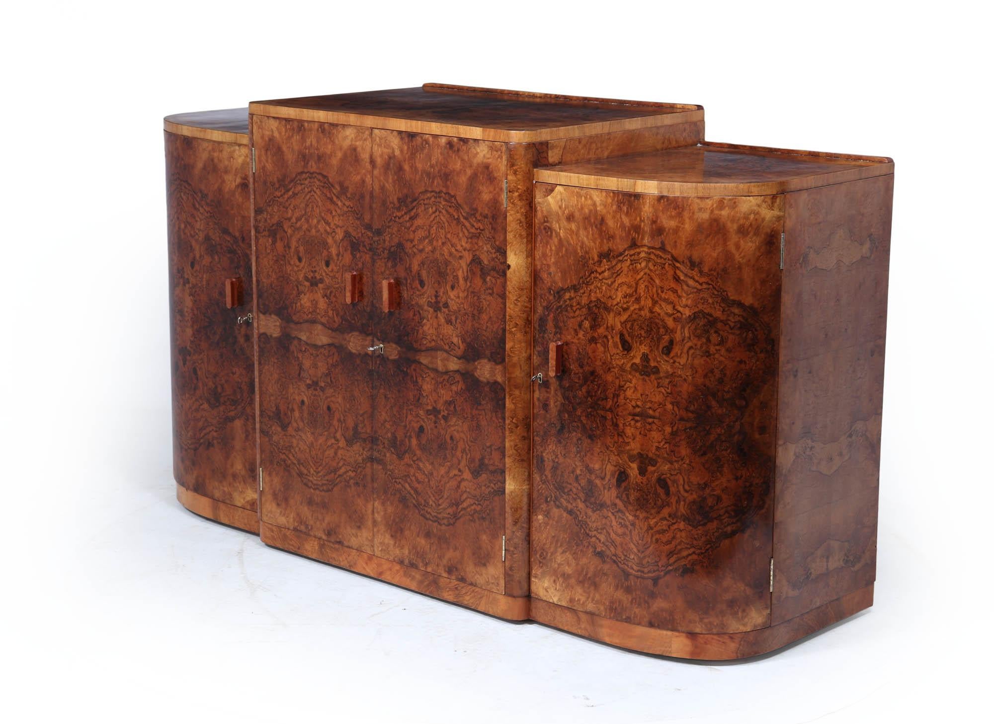 An exceptional English Art Deco sideboard, circa 1930, with beautifully bookmatched figured walnut including sections of burr. Comprising four doors, the central two concealing four drawers with military-style inset chrome handles. Original wooden