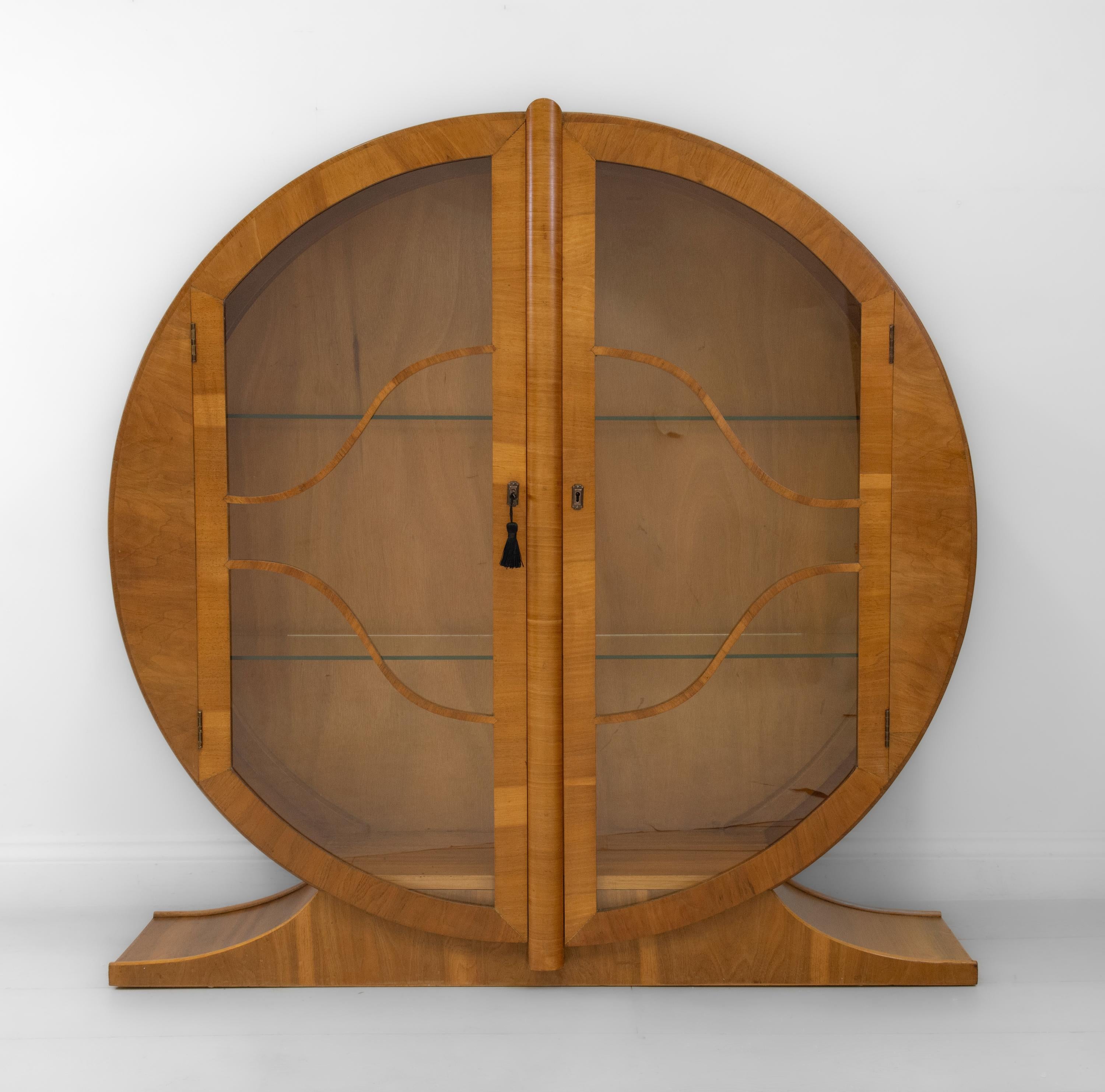 A fabulous Art Deco circular figured walnut display cabinet on splayed base. Circa 1930's.

Veneered in highly figured walnut, with solid walnut edgings, the cabinet is an original 1930's example and in very good condition for its age. It has been