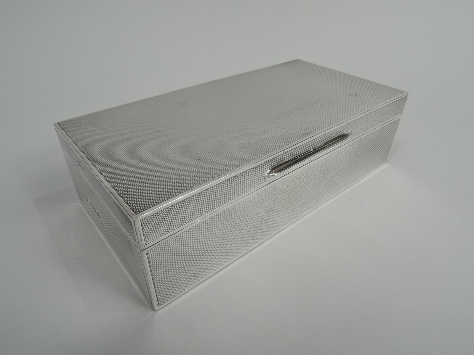 Art Deco sterling silver box. Made by C. J. Vander, Ltd in Birmingham in 1970. Rectangular with straight sides. Cover flat, hinged, and tabbed. Allover engine-turned ornament in plain borders. Box and cover interior cedar lined and partitioned. Box