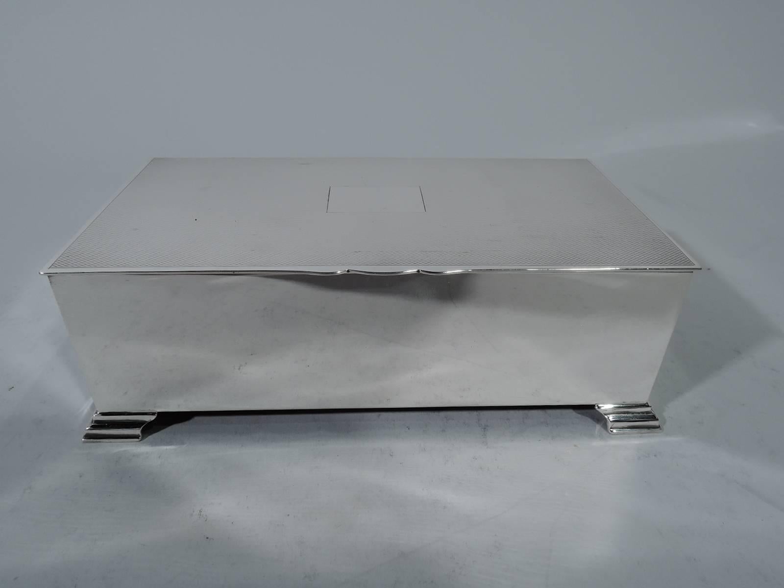 Art Deco sterling silver desk box. Made by John B. Chatterley & Sons in Birmingham in 1955. Rectangular with plain and straight sides. Cover flat and hinged with scalloped tab and central rectangular frame (vacant) surrounded by dense engine-turned