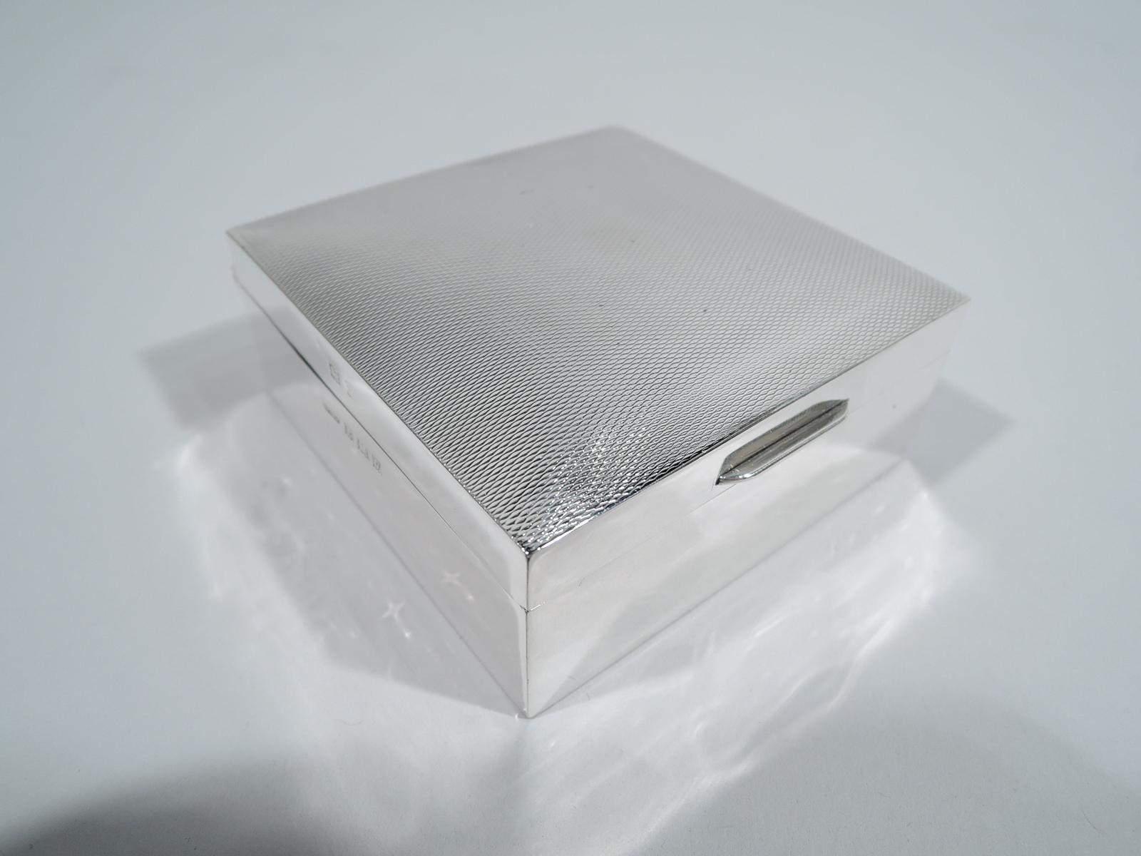 English Art Deco sterling silver trinket box, 1956. Square with plain and straight sides. Cover hinged and gently curved with tab and allover engine-turned wave ornament. Box and cover interior cedar lined. Underside inset with laminate. Fully
