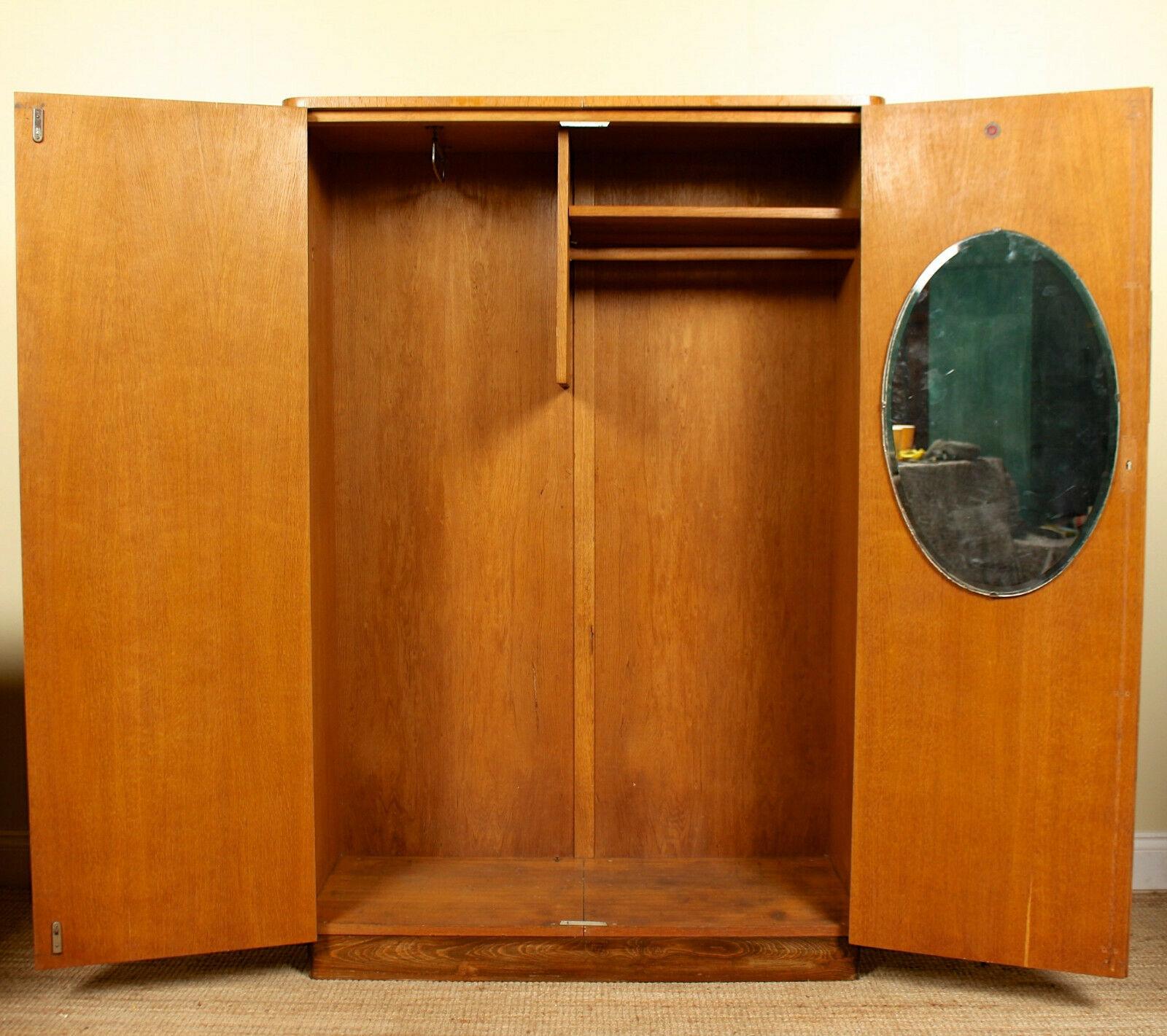 An impressive Art Deco inlaid oak wardrobe. The doors with inlaid central motif, mounted with good carved oak handles and enclosed two hanging rails, shelving and mirror. Raised on a nicely contrasting stained oak plinth base.
  