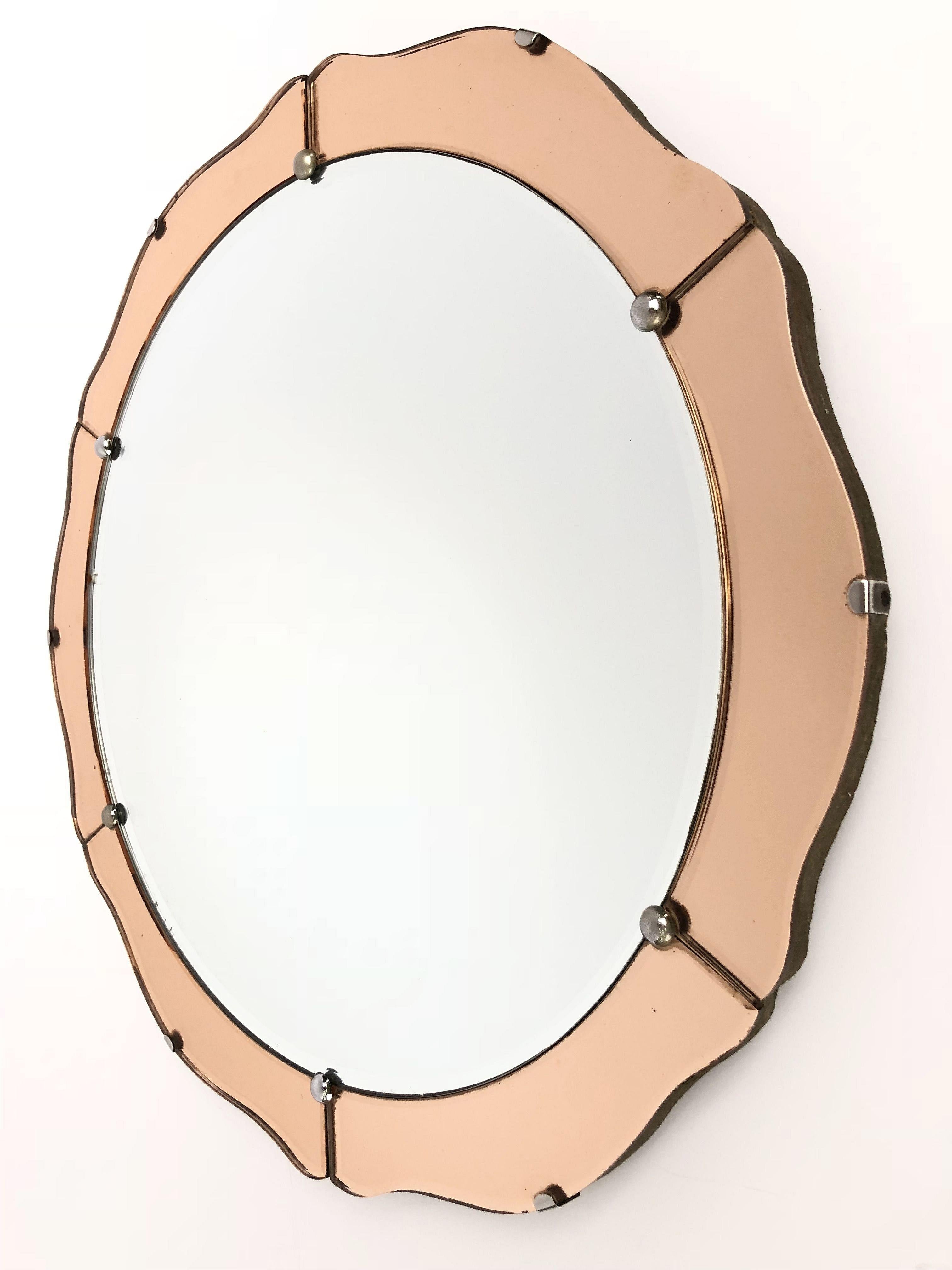 A fine English round or circular mirror from the Art Deco period, featuring a serpentine edge of reflective copper colored mirrored glass around a mirrored glass centre, mounted to a wood backing.

Measures: Diameter 19 3/4 inches