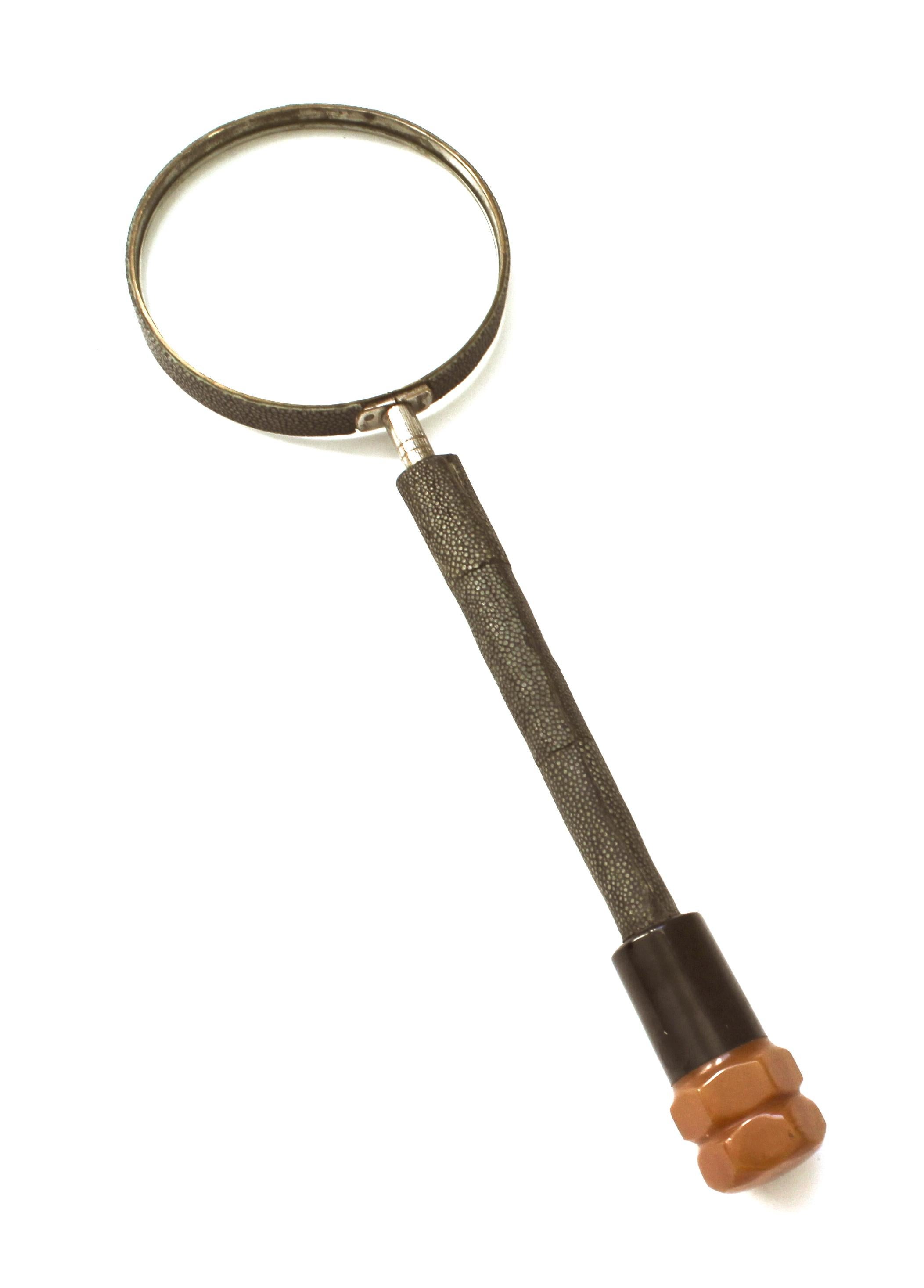 This stylish English Art Deco magnifying glass was acquired in London and it dates to the 1920s-1930s.

The piece is fabricated in shagreen and bakelite.