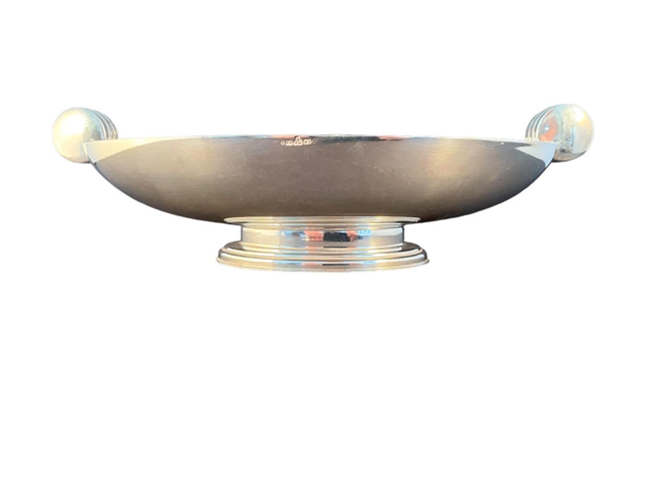 English Art Deco silver plate footed bowl of oval form with vertical disk handles with reeded edge. Incomplete hallmark (..... '&' over F.M.) upper part missing.