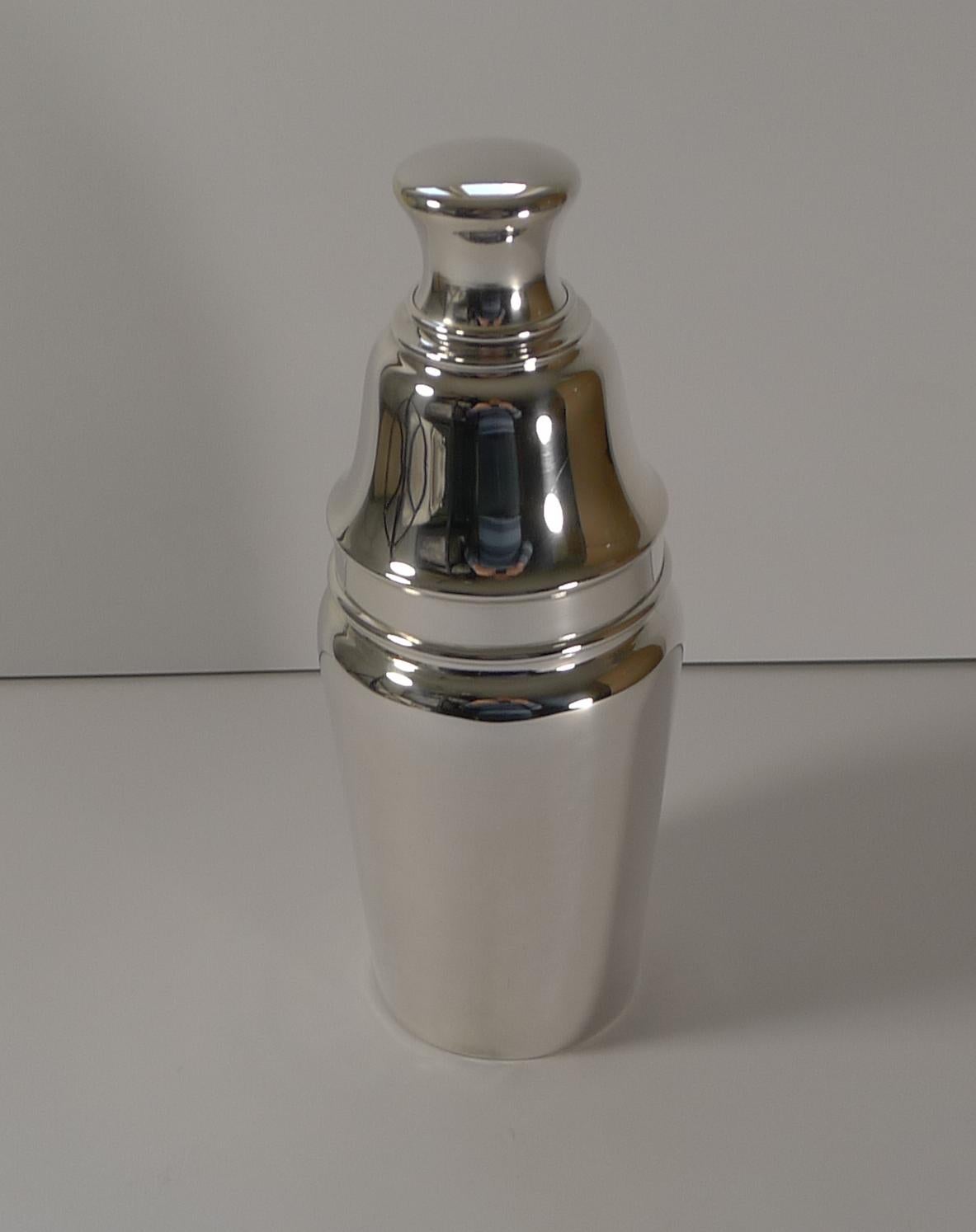 An unusually shaped and very elegant cocktail shaker made in silver plate having been professionally cleaned and polished in our silversmith's workshop.

The underside is fully marked (three stars in a clover leaf) for Barker Brothers of