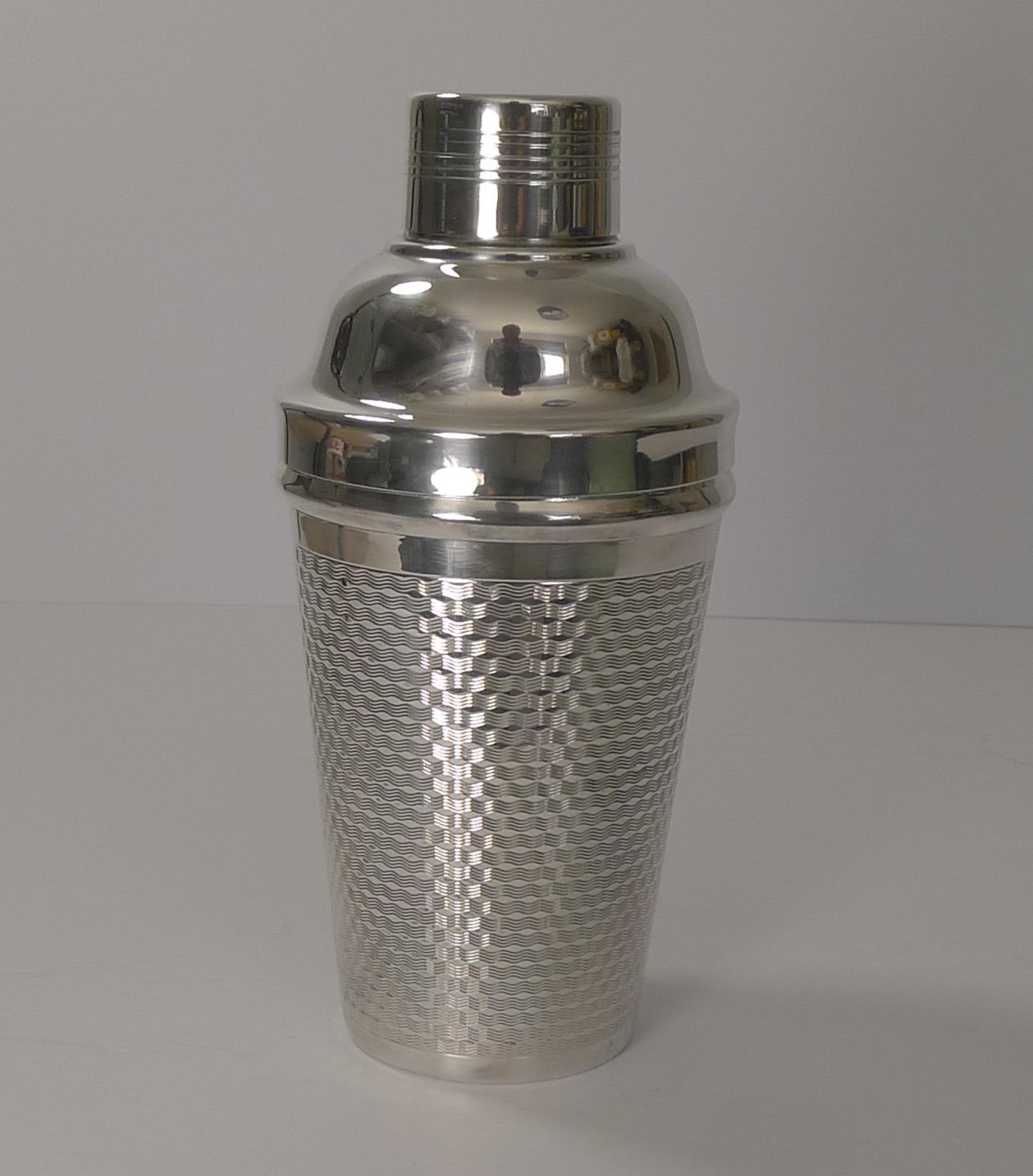 A stunning Art Deco cocktail shaker in silver plate, in lovely condition inside and out, the body having beautiful engine turned decoration all around.

The underside is signed by the silversmith, W.A, I think for William Adams of Birmingham. It