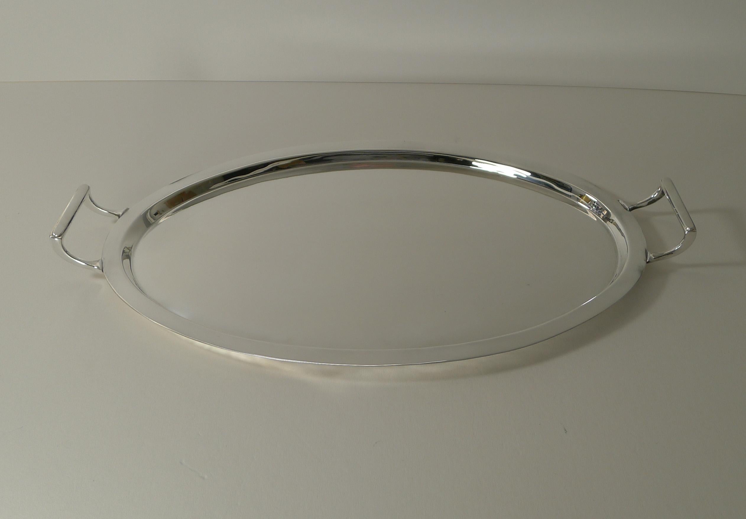 An elegant oval silver plated cocktail / serving tray with striking handles to either end.

Just back from our silversmith's workshop where it has been professionally cleaned and polished, restoring it to it's former glory.

The underside is