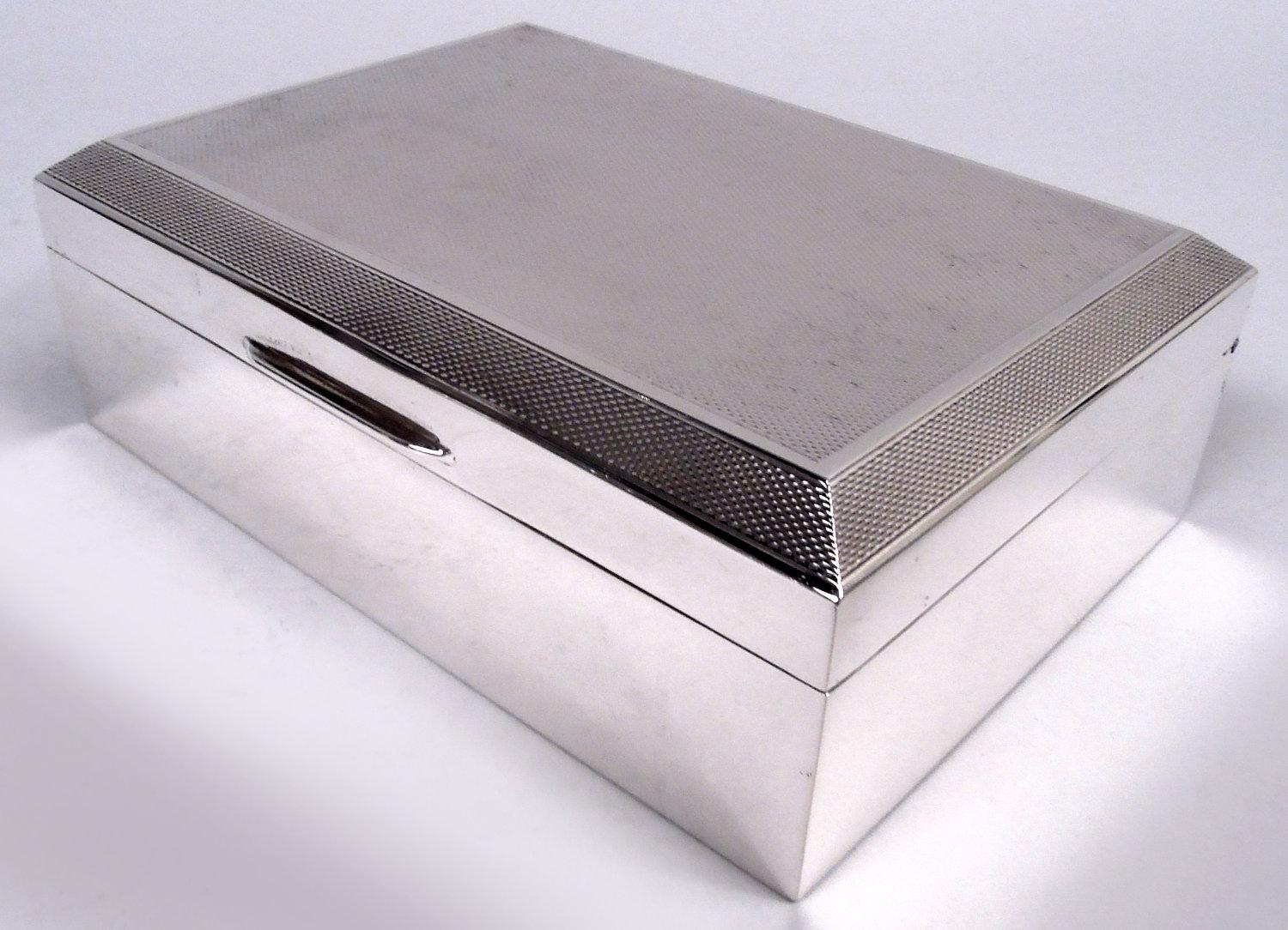 Caja inglesa Art Decó de plata de ley, 1957. Rectangular con lados lisos. Tapa abisagrada y tabicada con parte superior plana y bordes achaflanados; ornamento torneado en todo el contorno. Interior forrado de cedro; parte inferior forrada de cuero.
