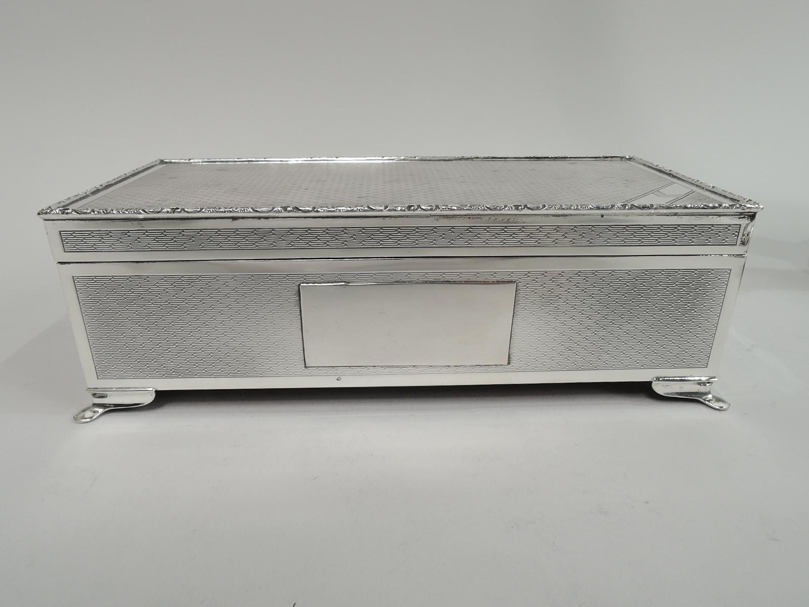 Elizabeth II sterling silver box. Made by Harman Bros. in Birmingham in 1982. Excellent condition. Rectangular with straight sides. Cover flat and hinged. Engine-turned wave ornament in plain frames. Front has rectangular mono plate. Cover top has