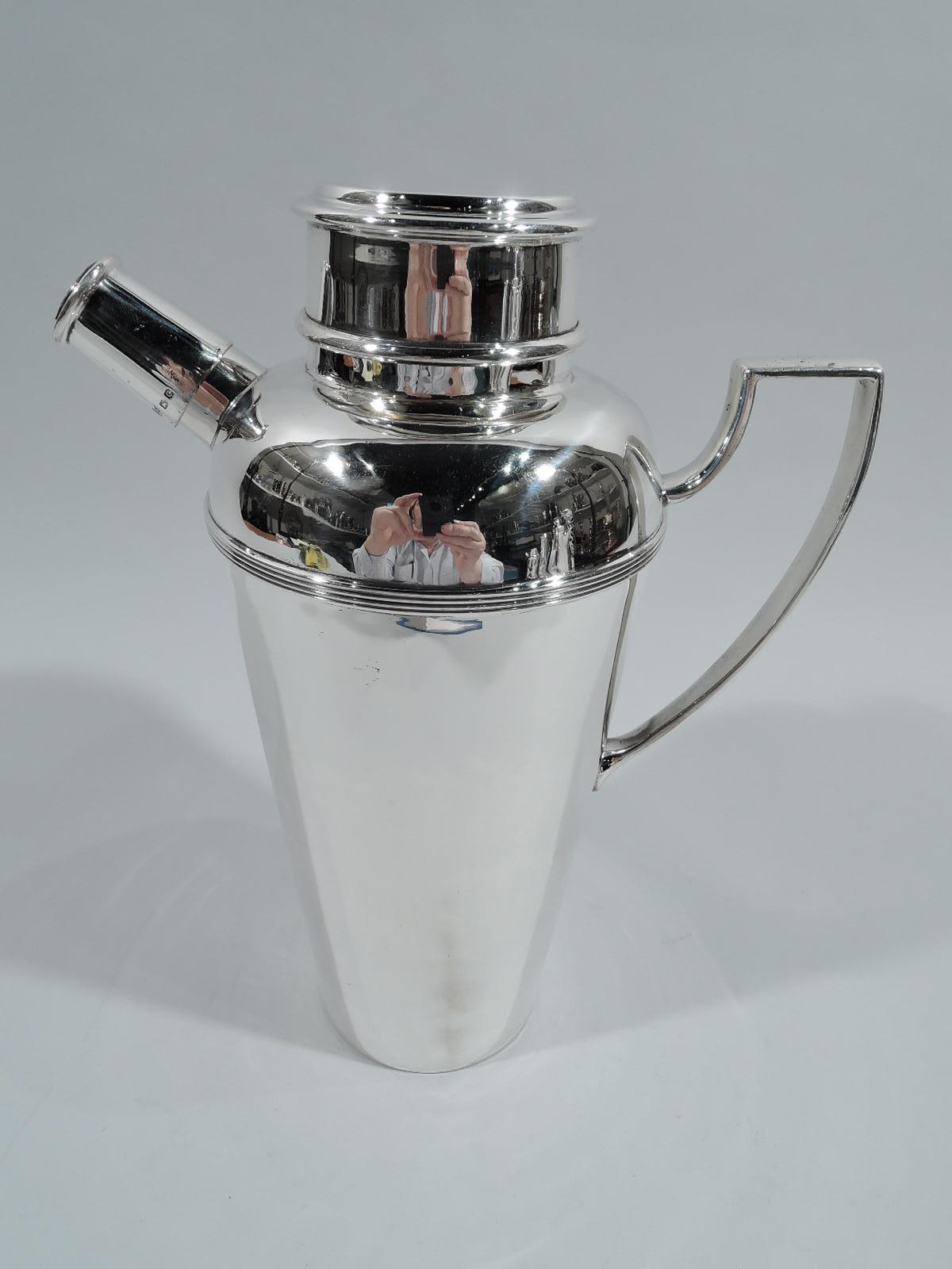 George V sterling silver cocktail shaker. Made by Mappin & Webb in Birmingham in 1927. Straight and gently tapering sides, curved shoulder with reeded band, scroll bracket handle, and short inset neck with snug-fitting cover. Stubby diagonal spout