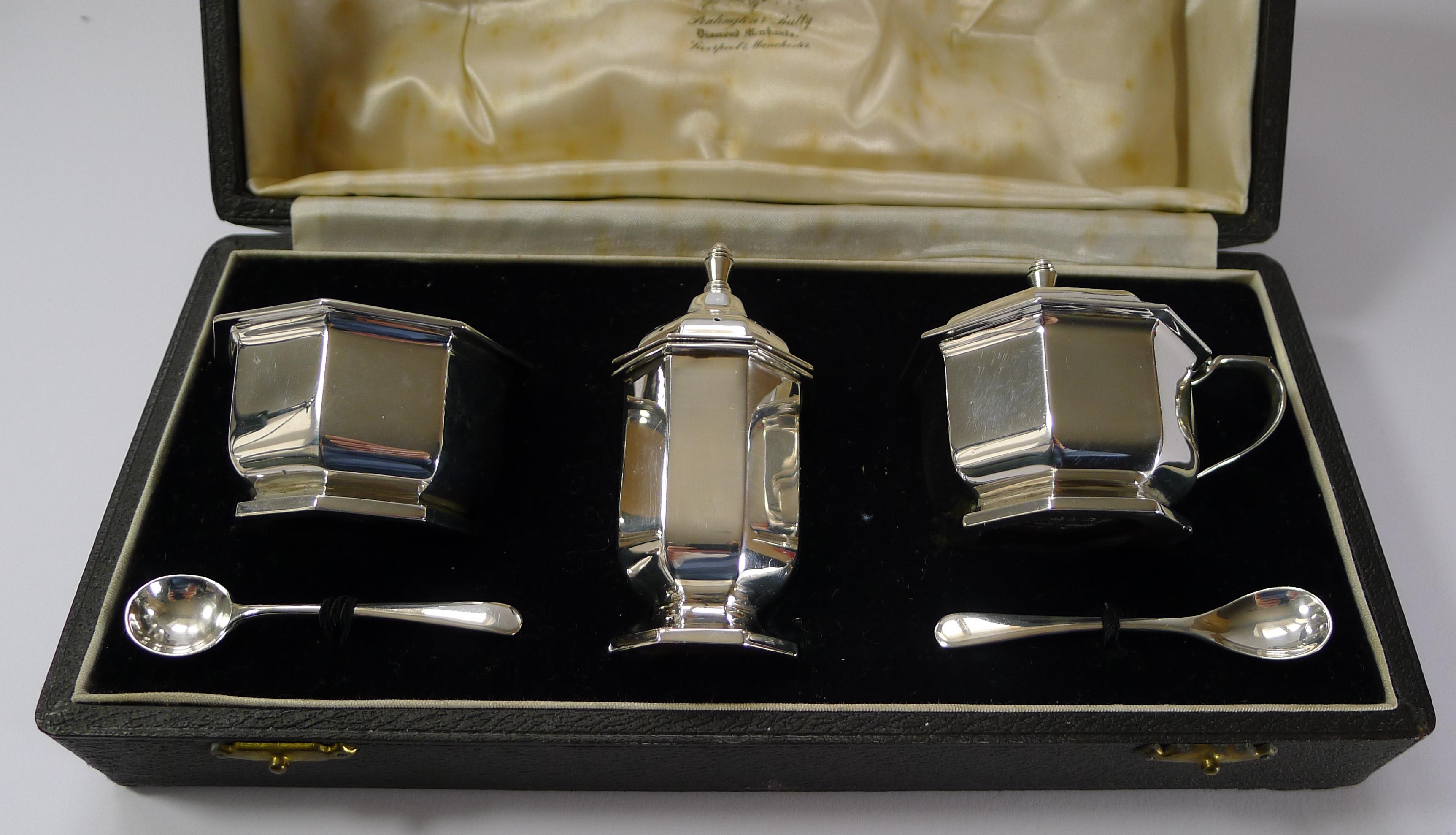 A handsome English sterling silver condiment / cruet set consisting of a mustard pot and spoon, an open salt and spoon and a pepper pot.

Beautifully and simply designed in Art Deco style and each piece clearly hallmarked for Birmingham 1947, late