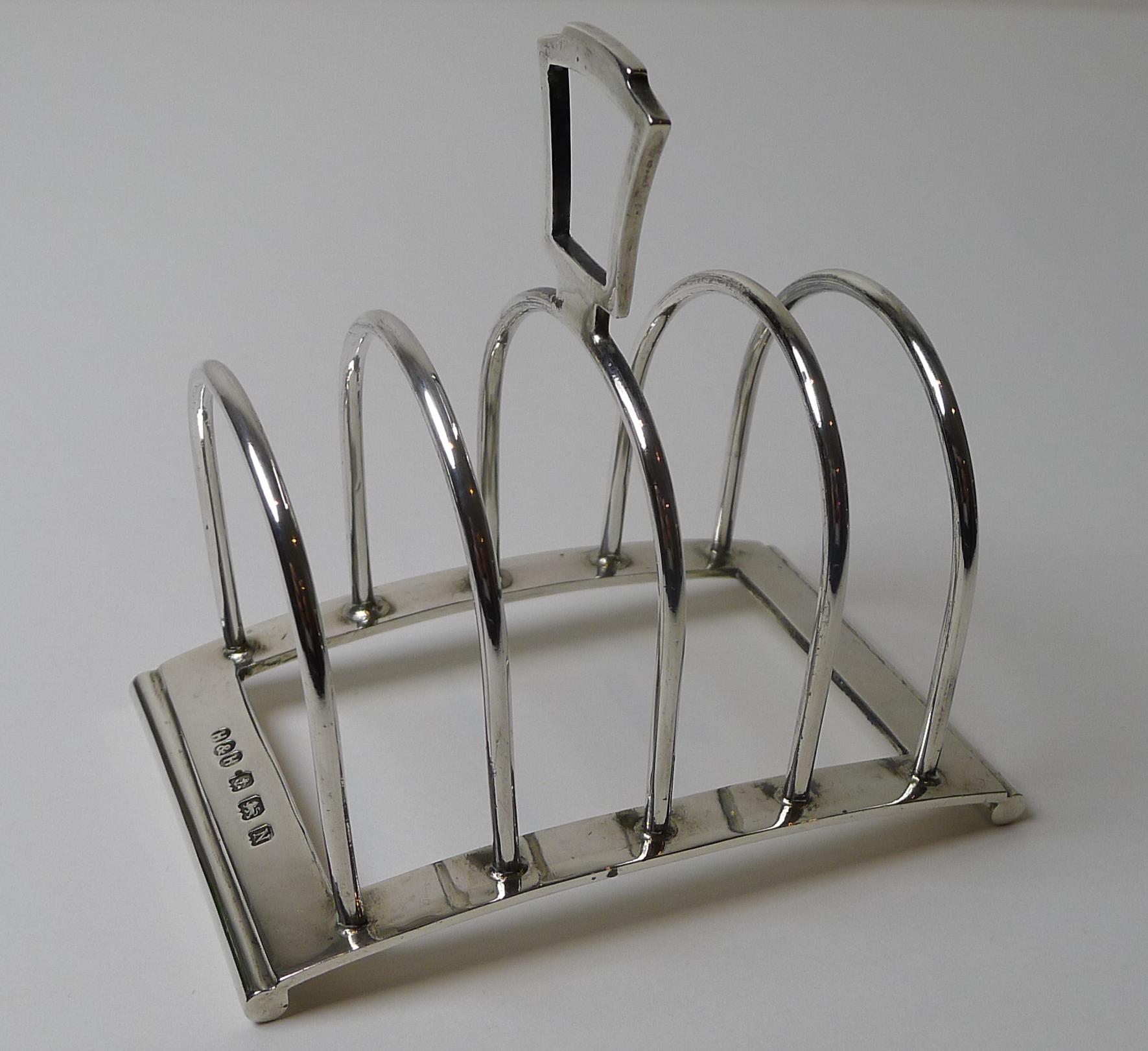 A wonderful little toast rack which would look equally impressive on a smart desk-top to organise small papers, business cards etc.

Made from solid English sterling silver it was made by the highly collectable and sought-after silversmith, Hukin