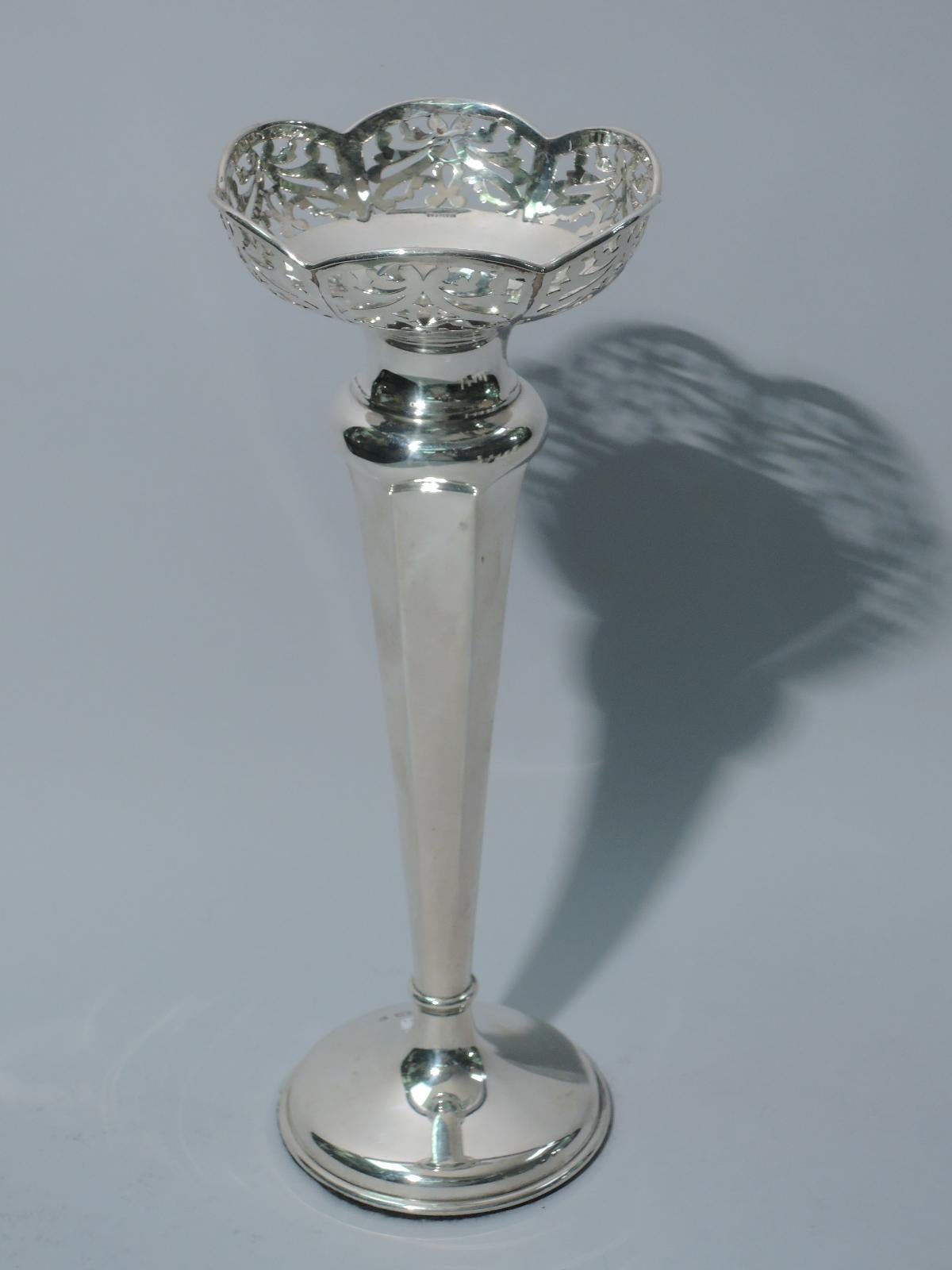George V sterling silver vase. Made by Alexander Clark in Birmingham in 1923. Straight and faceted sides, small knop, and raised foot. Molded and scalloped rim with curved and pierced sides. Weighted. Fully marked. Weighted.