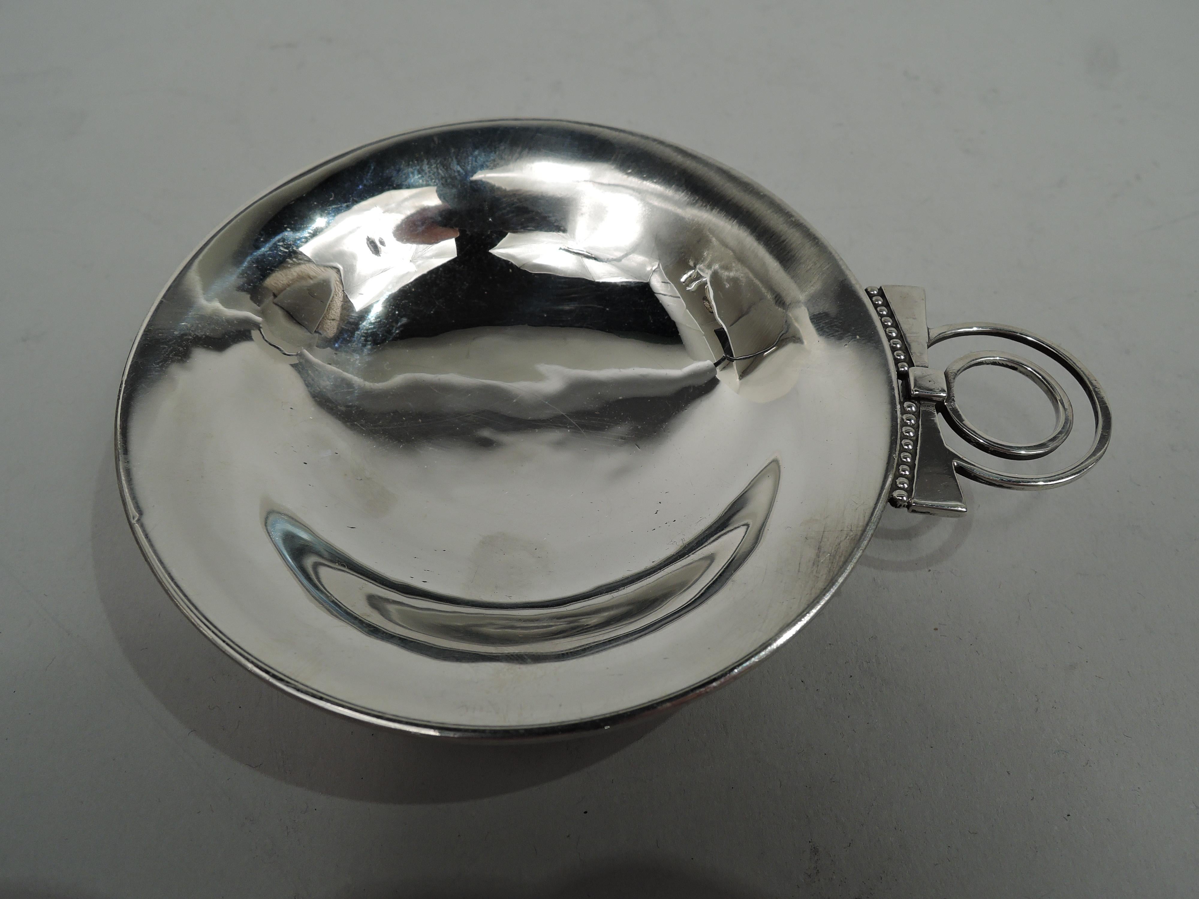 Edward VIII sterling silver vide-poche. Made by Charles Boyton in London in 1936. Round and shallow with beaded foot ring. Double concentric ring handle with beaded bowtie mount. Visible hand hammering. Fully marked. Weight: 2.5 troy ounces.