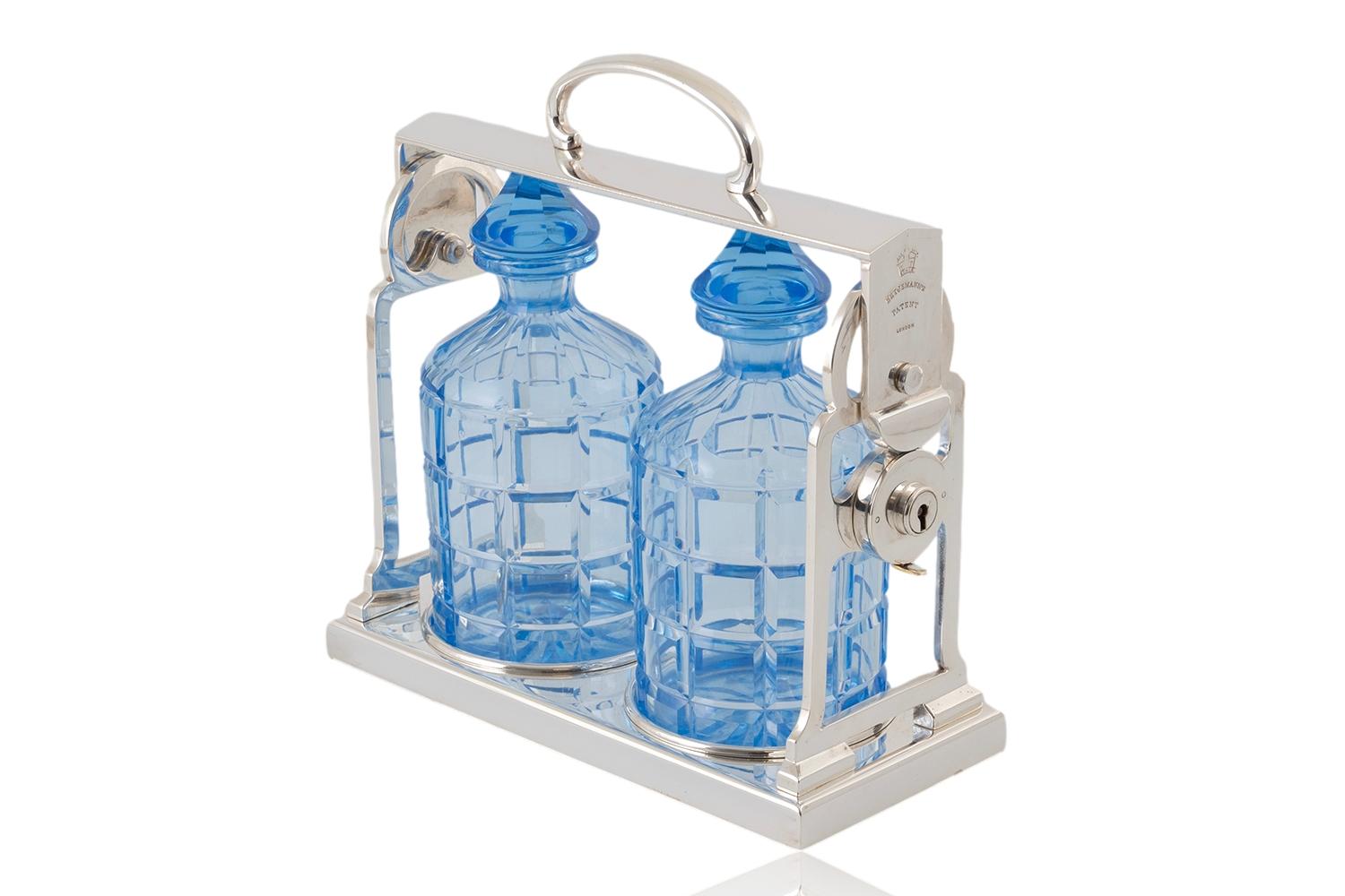 Rare Model with Original Blue Hue Bottles 

From our Decanter collection, we are delighted to introduce to the market this Art Deco Twin Bottle Tantalus George Betjemann. The Twin Bottle Tantalus a rare example with silver plated frame housing two