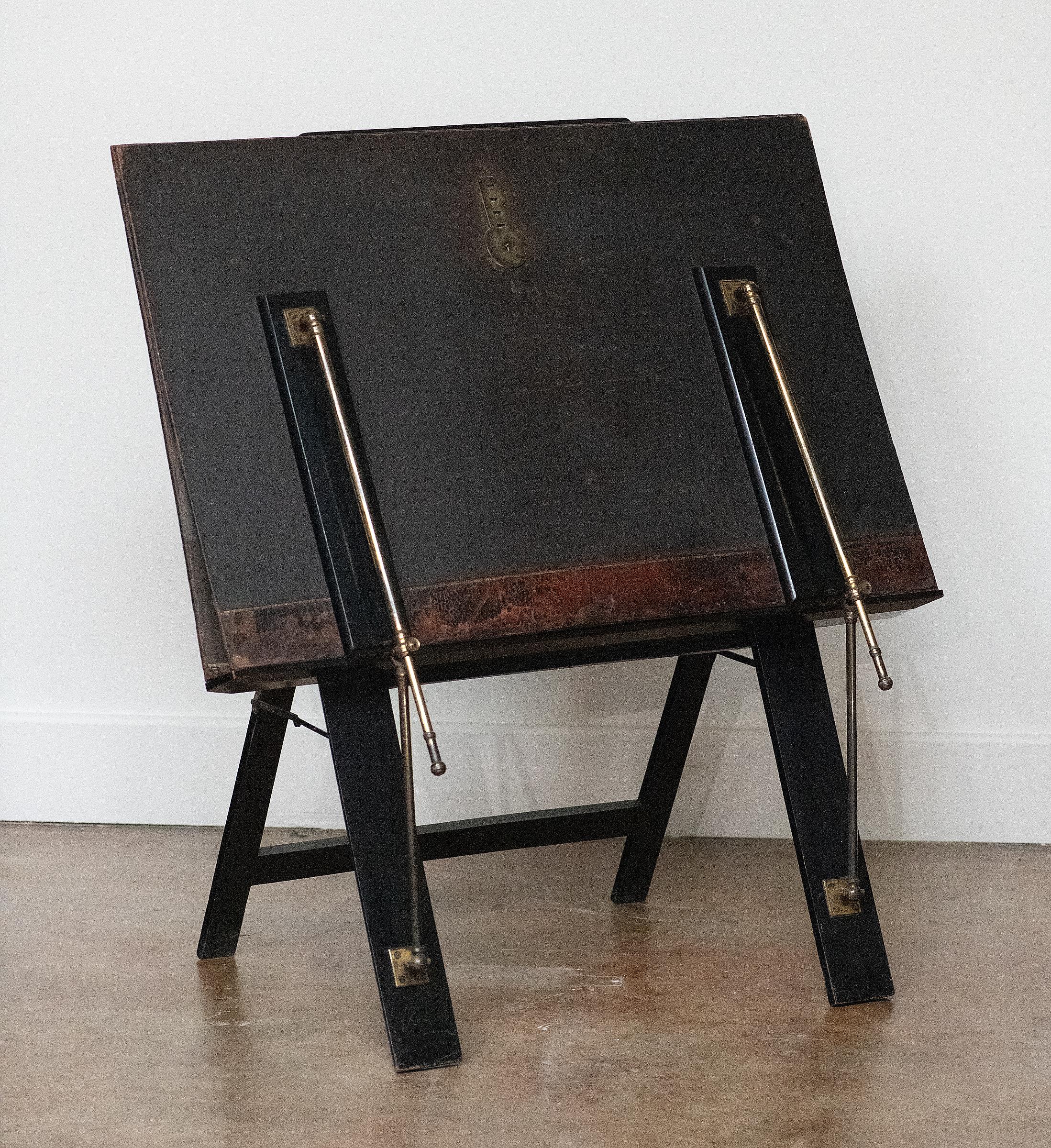 An English folio stand for art and engravings from the Edwardian era, patented by Bunyard of London. 
The folio stand is made like a book, compressed paper pulp with a leathered exterior which is finished with a gilt and tooled border. 
It is
