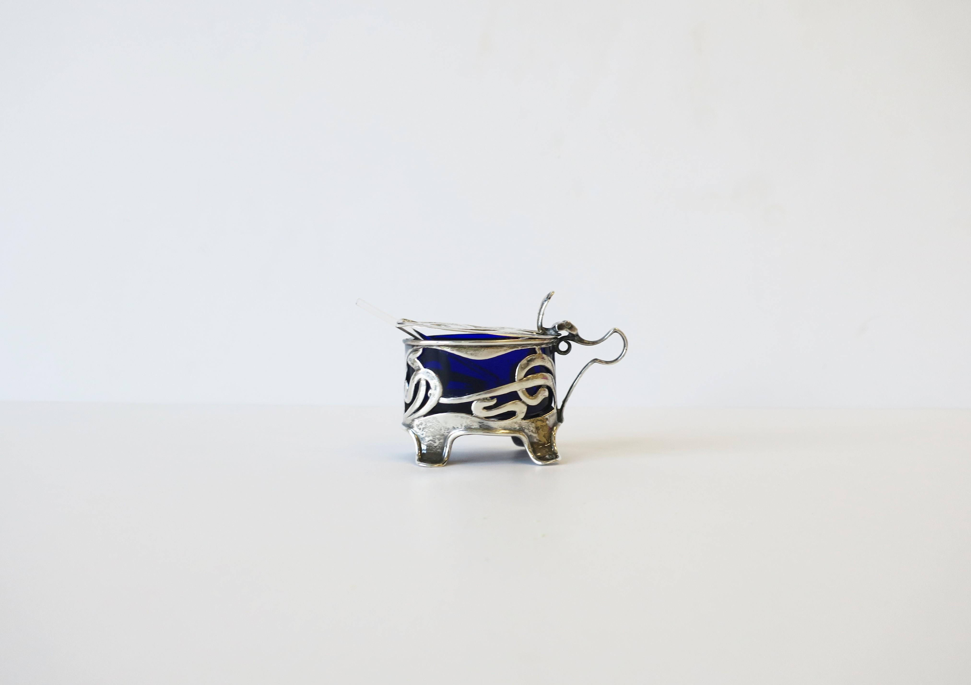 A beautiful English Art Nouveau sterling silver salt (or pepper) cellar, circa 20th century, England. Cellar or vessel has oval sapphire blue glass insert and comes with a small crystal spoon. With marker's and sterling silver mark's shown in image