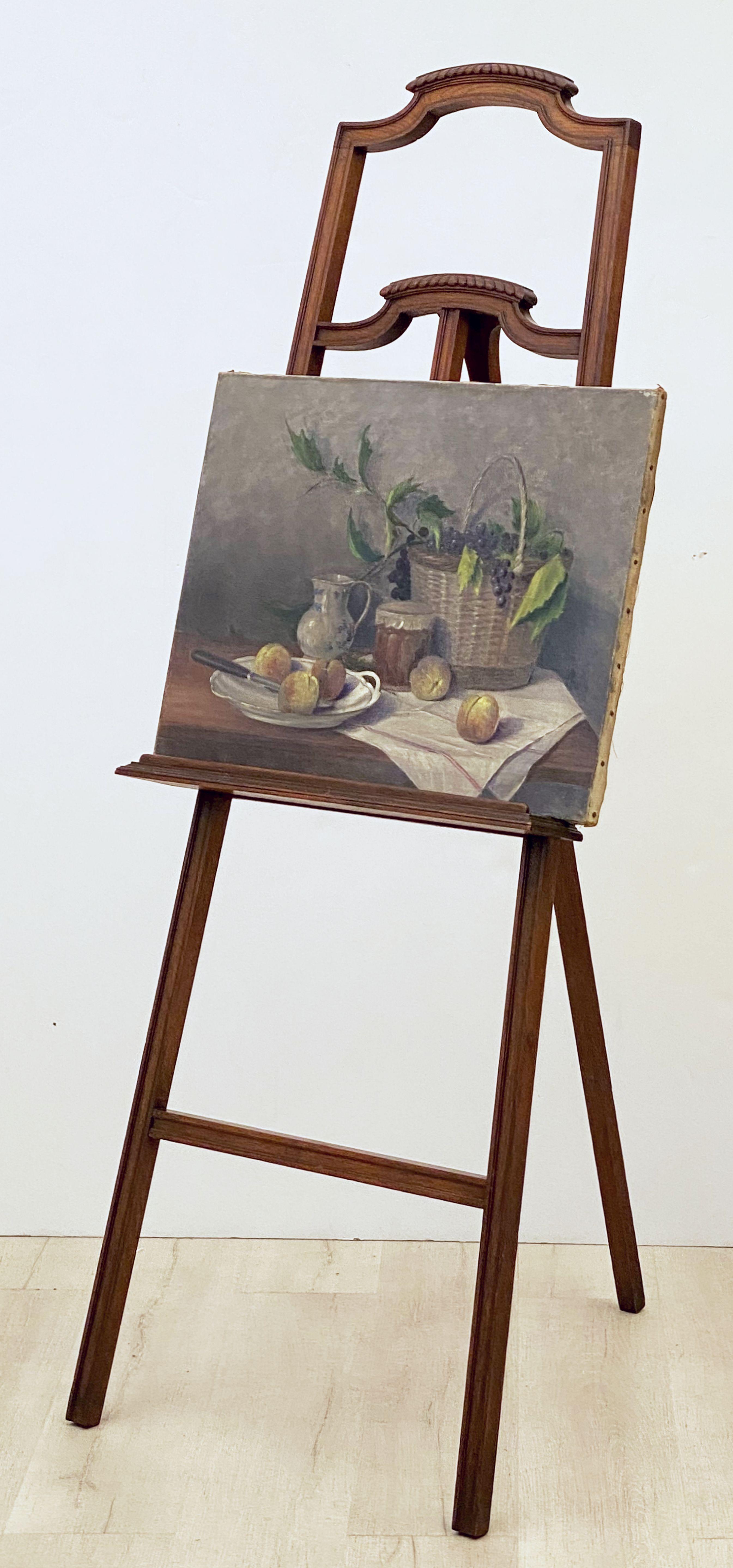 A fine English display or artist's easel, featuring a tripod stand with carved top panel, fixed gallery shelf, and wooden knobs for adjusting the height of the supports for the top of the displayed art.

Height with leg pushed in: 61 1/2