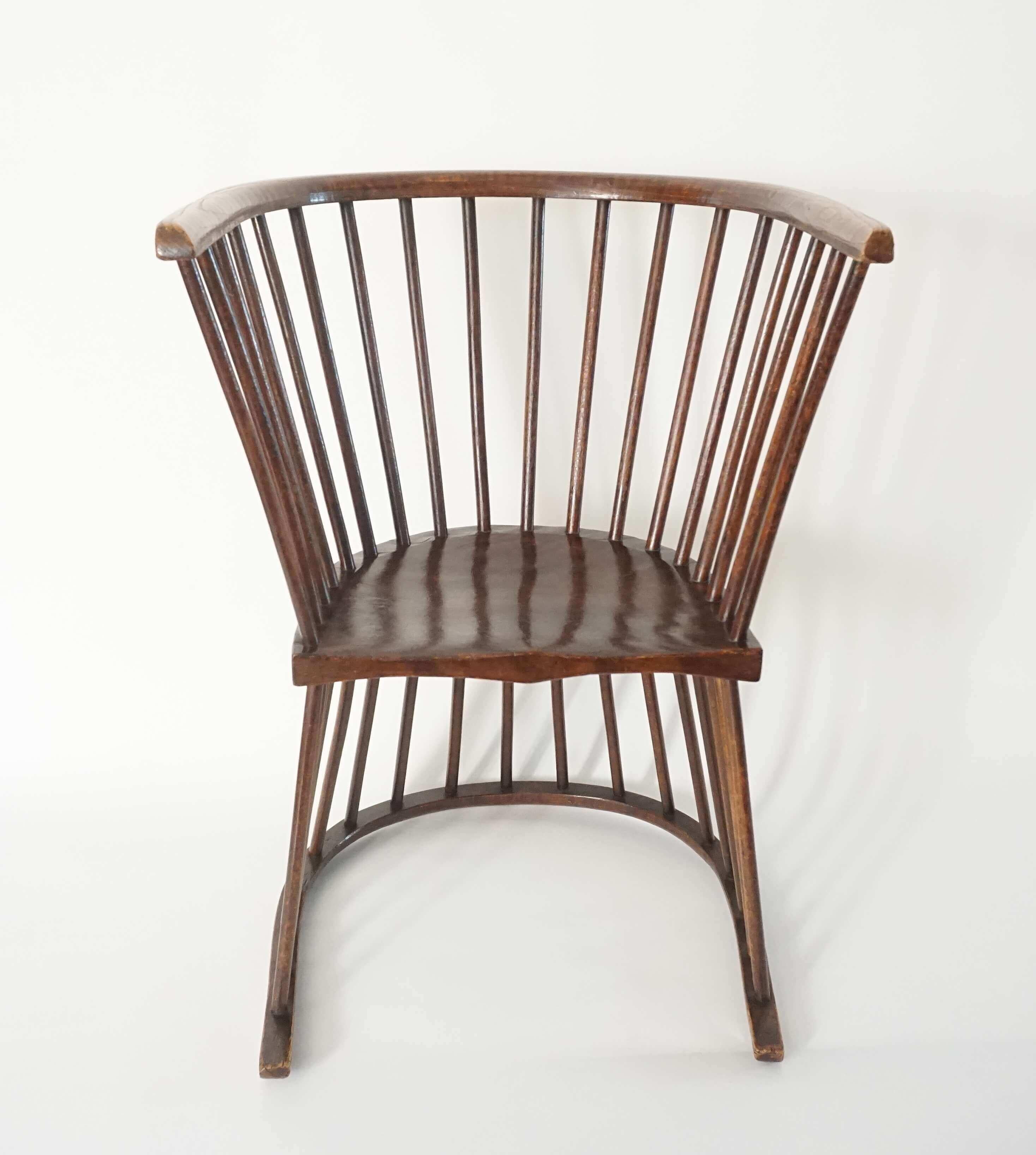English Arts & Crafts modified Windsor style chair of modernist or contemporary percept having double reversible (either 'sides' functional) 'horse-shoe' form and Circassian Walnut frame; the bent U-shape crest rails spindle joined to carve-shaped