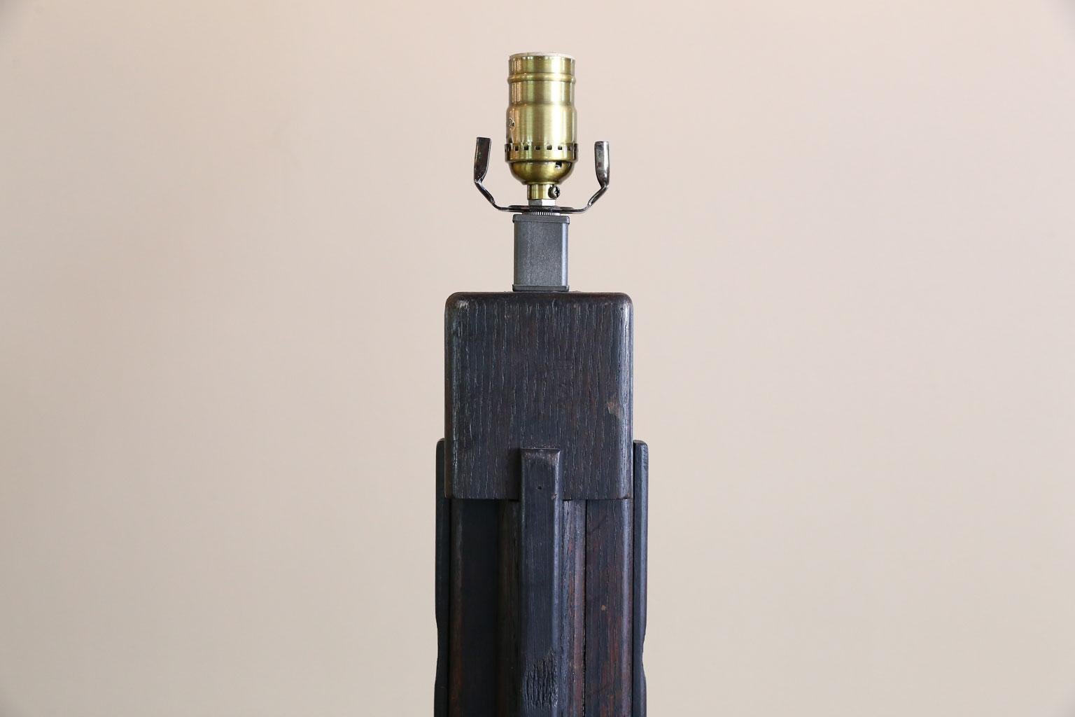This lamp is tall and a bit unusual. It was handmade and is a combination of oak that has been stained with a very dark brown stain and a black painted base. It has interesting reeding and has been wired for the US. The measurement is to the top of