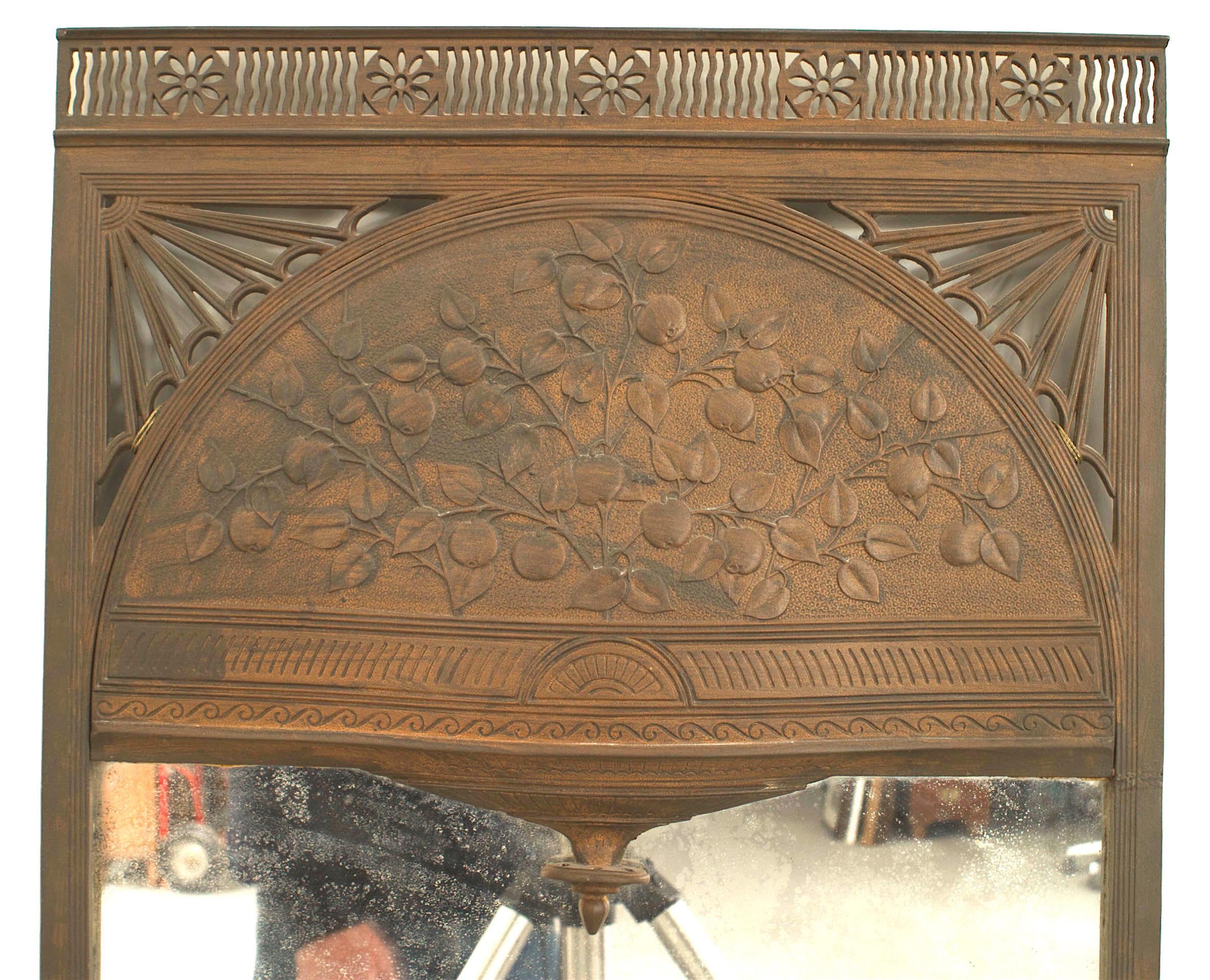 English Arts & Crafts iron mirror with a pierced frame surrounding a floral scene.
