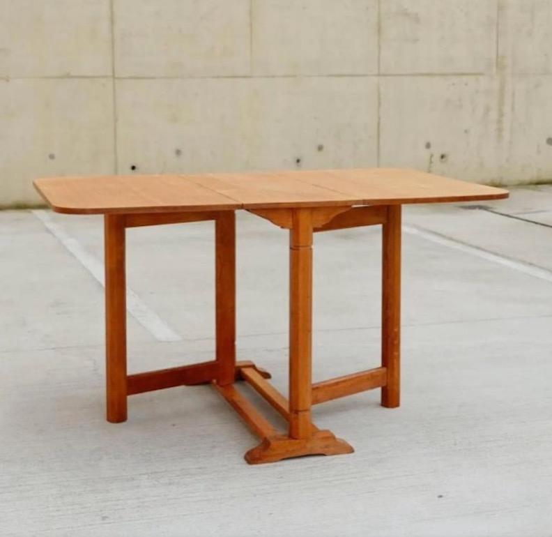 A beautiful Arts & Crafts Cotswold School drop leaf table in solid oak. This table has the most beautiful details and patina, with chunky octagonal shaped legs in a honey toned oak. The octagonal legs were synonymous with the Arts and Crafts