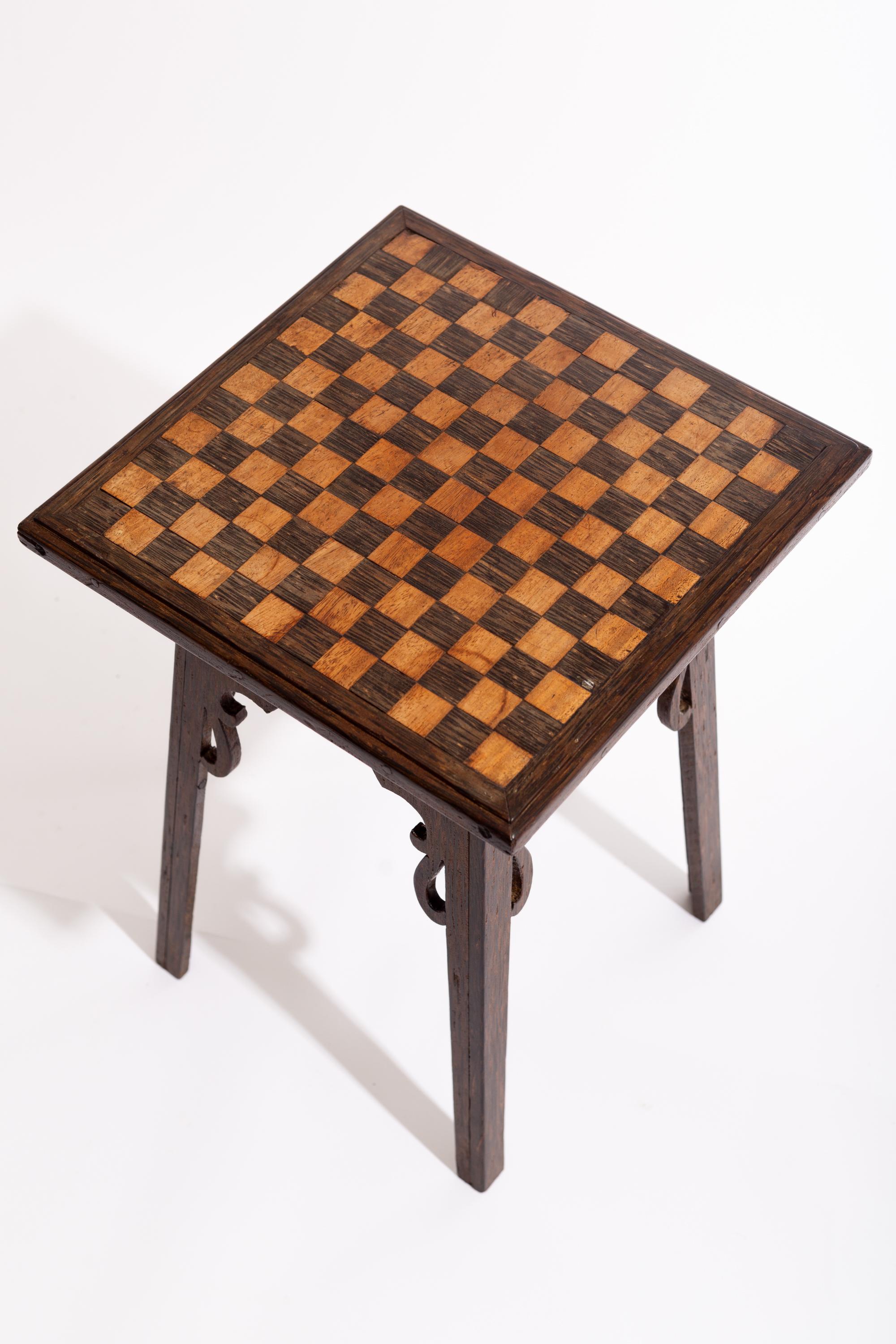 A late 19th Century Arts and Crafts occasional table with a checkerboard inlaid top.

Made in an unusual fruitwood, possibly coromandel.