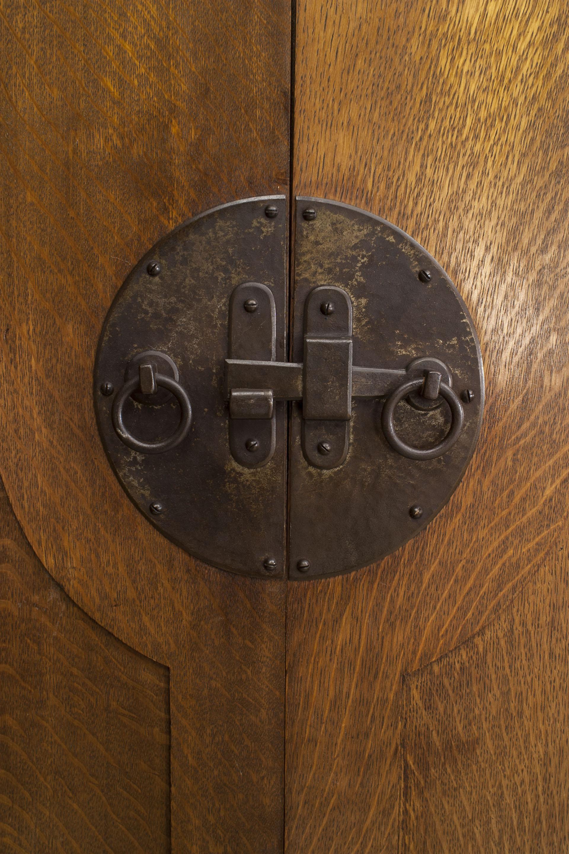 Armoire en chêne de style Arts & Crafts avec un meuble haut et un meuble bas à portes coulissantes et un motif floral sculpté centrant un meuble à 2 portes (peut-être LIBERTY).
